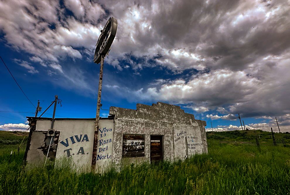 An abandoned gas station in Tierra Amarilla, New Mexico, with graffitti telling everyone to remember the courthouse raid of 1967.