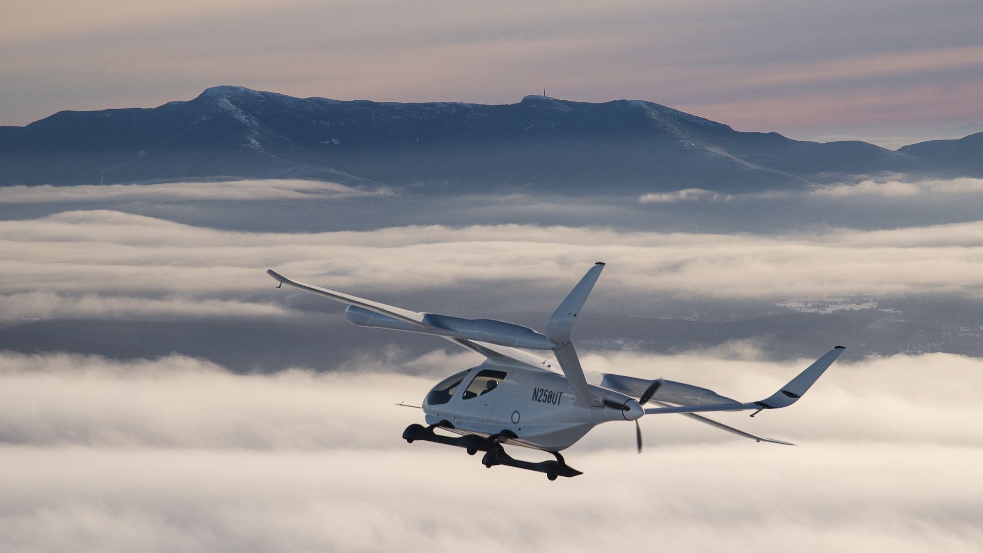 Beta Technologies' electric aircraft flying in front of a mountain.