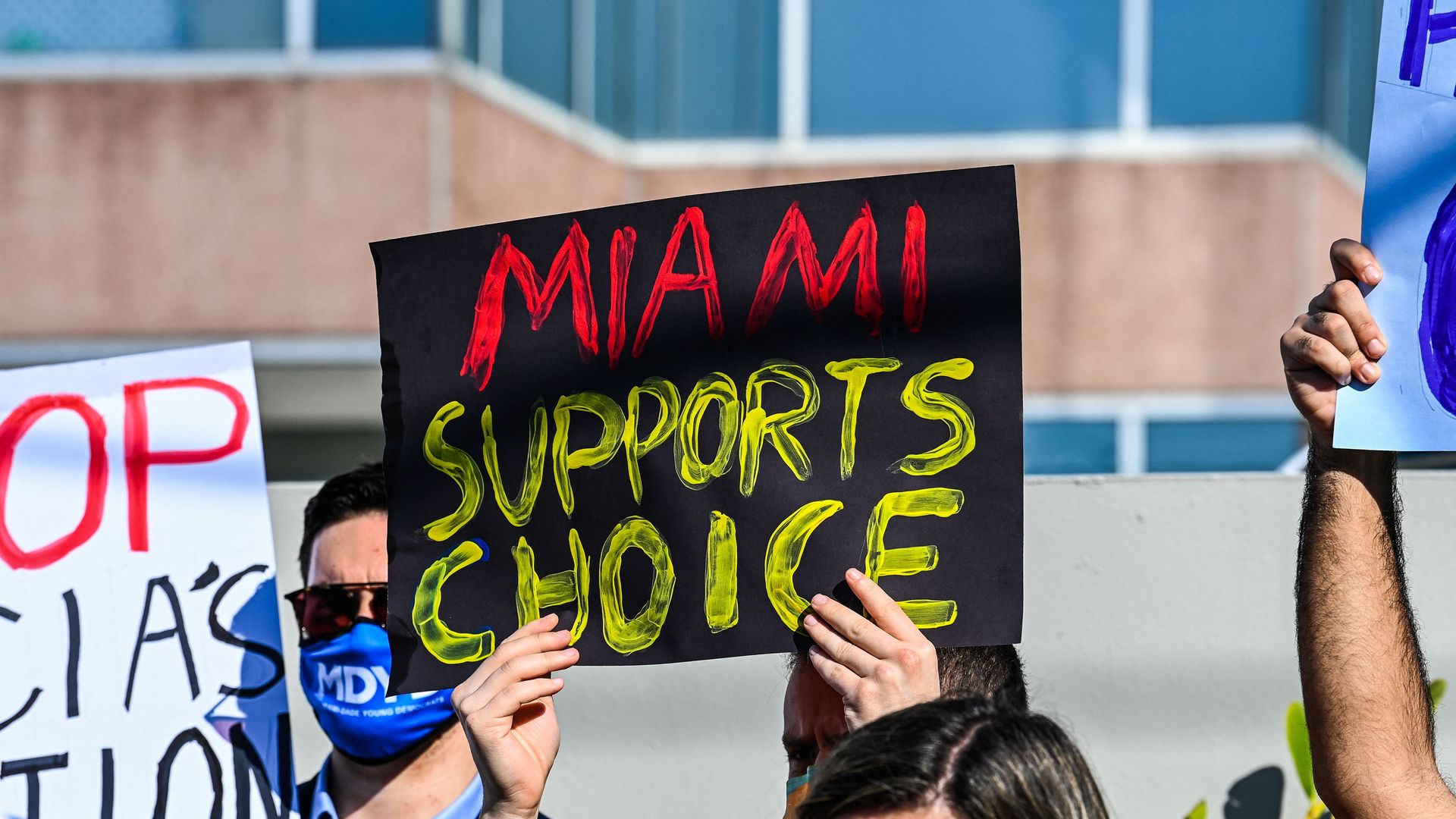 People hold placards as they protest against Florida's 15-week abortion ban in front of the office of State Senator Ileana Garcia in Coral Gables, Florida, on January 21, 2022.