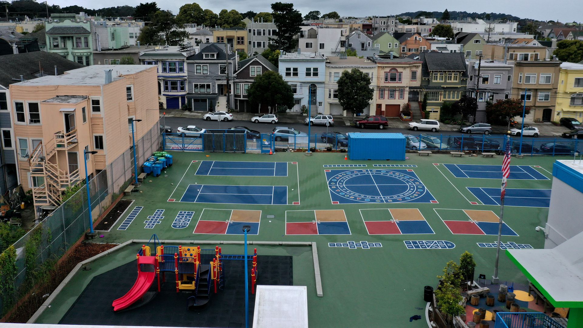 Photo (aerial view) of a schoolyard, including a playground and an American flag at Frank McCoppin Elementary School