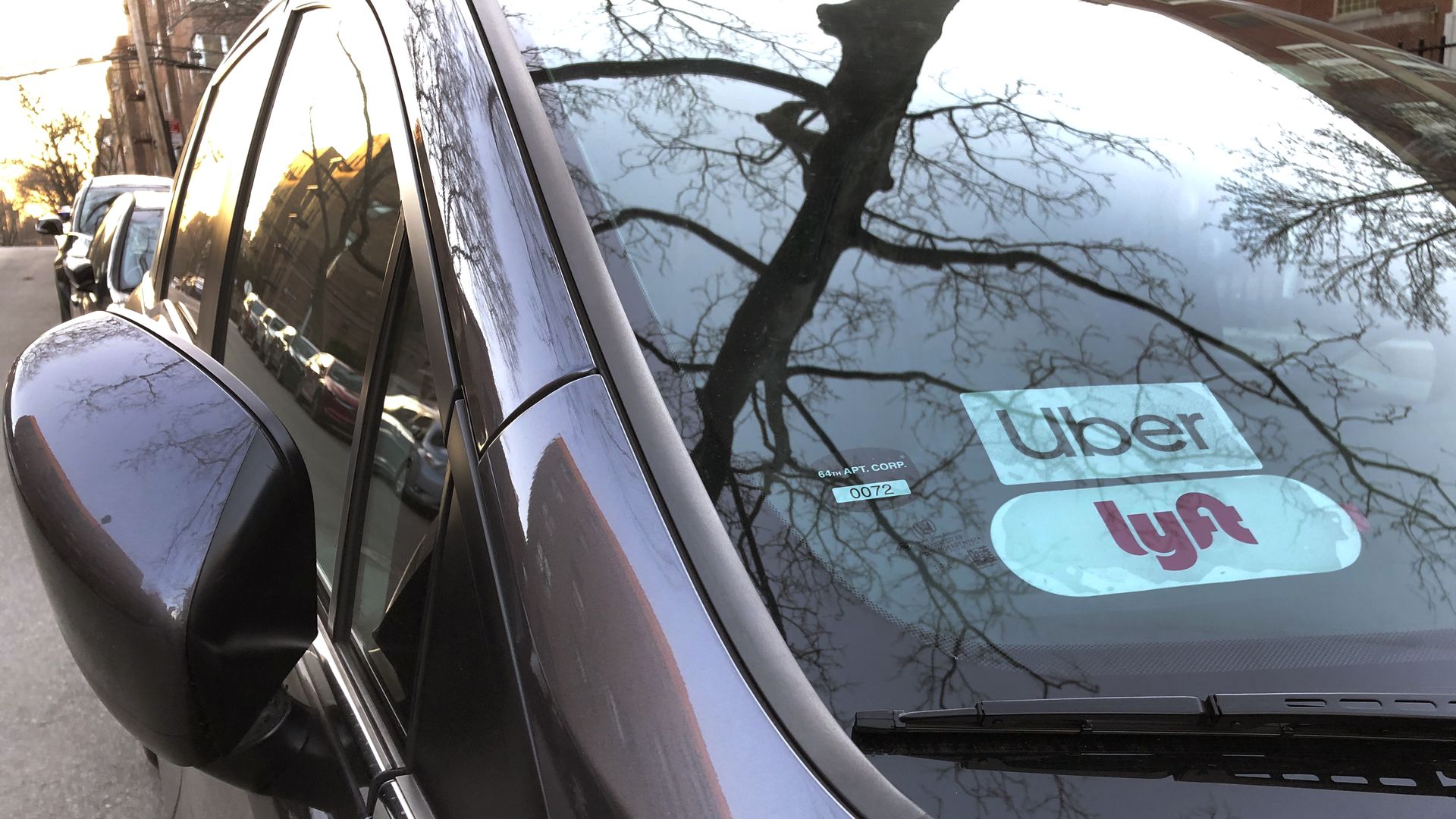 Uber and Lyft sign in windshield of car.