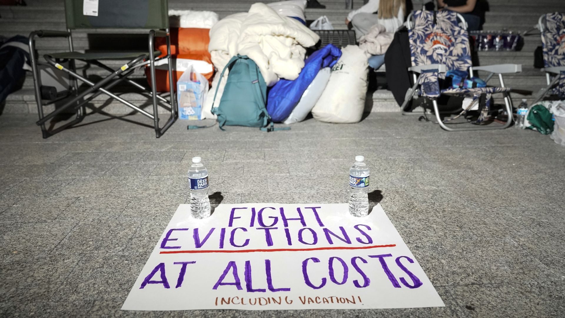 A sign calling for fighting evictions is set on the ground as Rep. Cori Bush (D-MO) spends the night outside the U.S. Capitol.