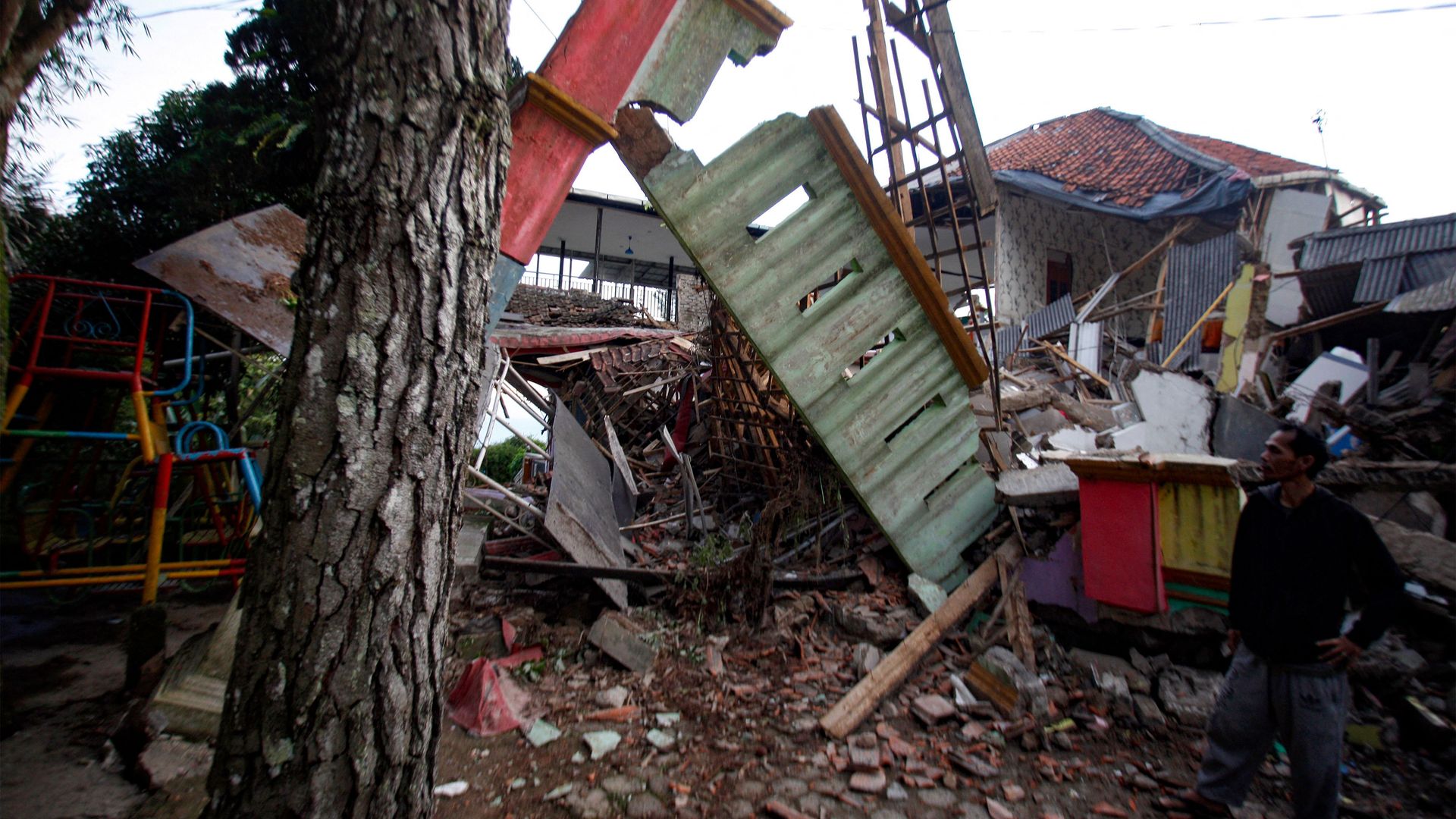 A man stands beside damaged houses following an earthquake in Cianjur on November 21