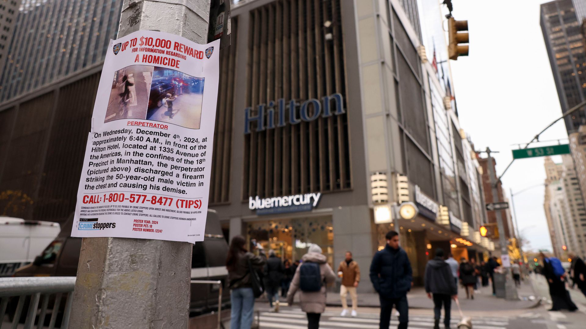 A photo of a sign on a light pole offering a 10,000 reward for helping find Brian Thompson's killer 