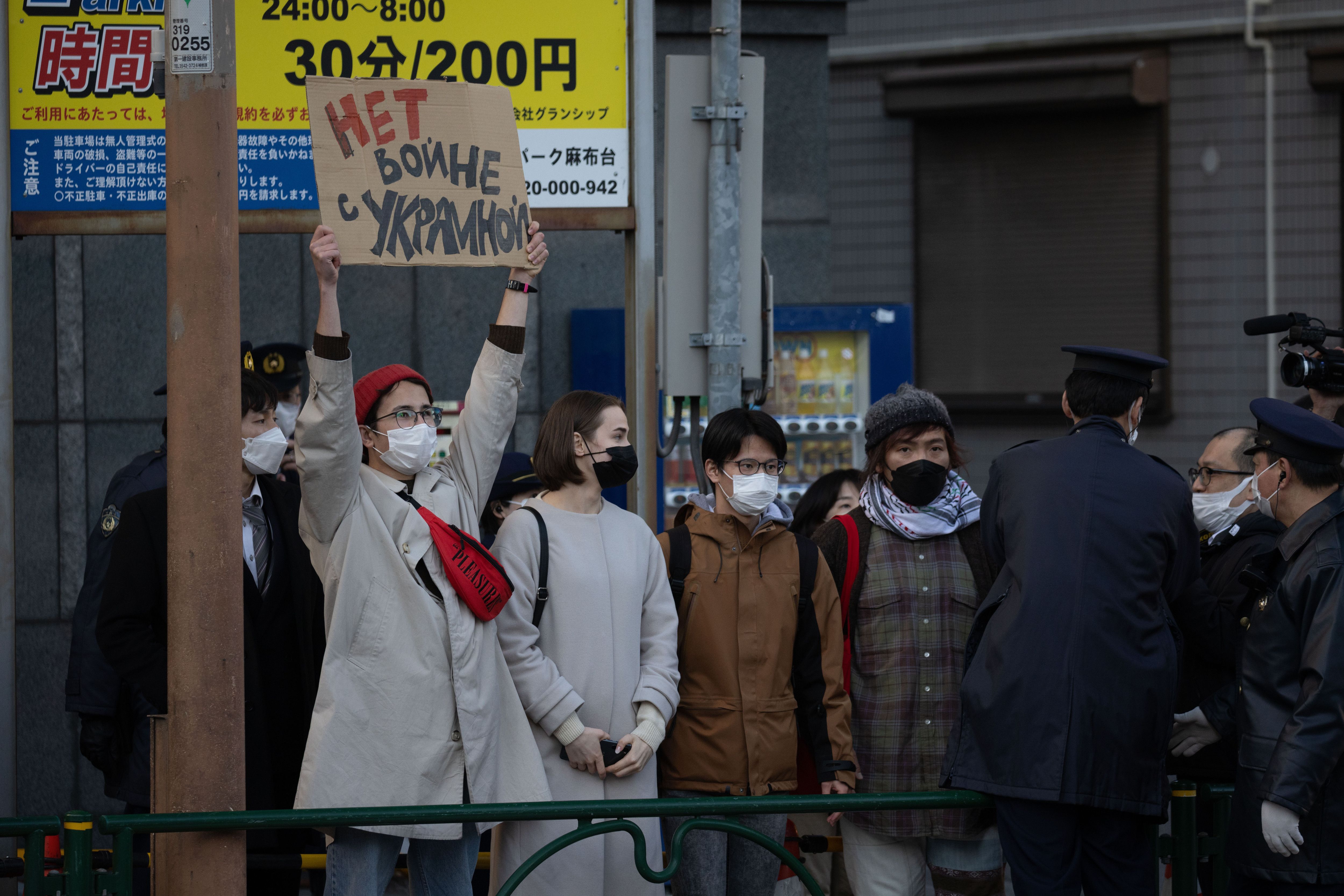 A protester holding a sign reading "No war with Ukraine" in front of the Russian Embassy in Tokyo on Feb. 24.