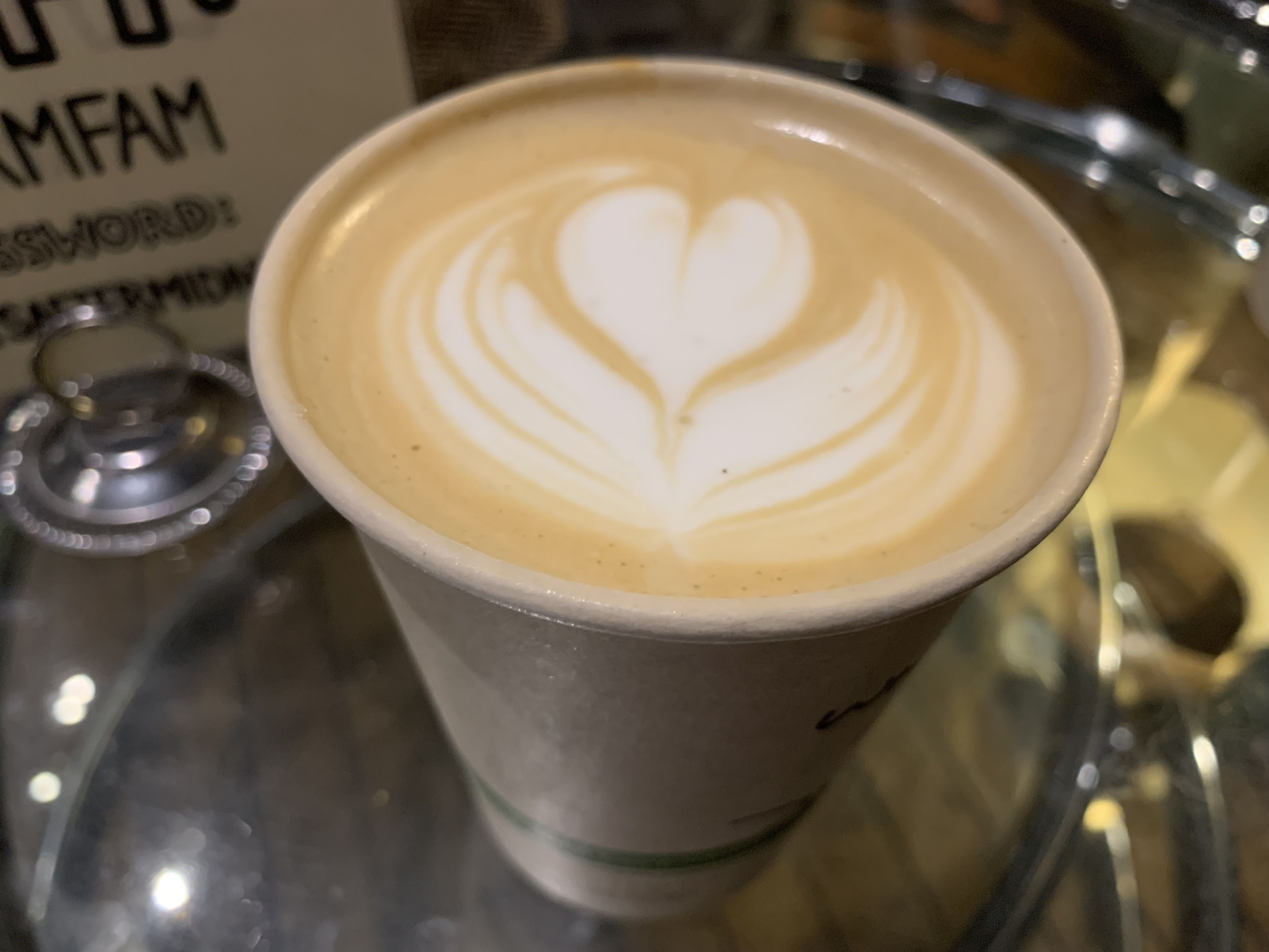 Photo of a cup of coffee with an artistic heart made from the foam.