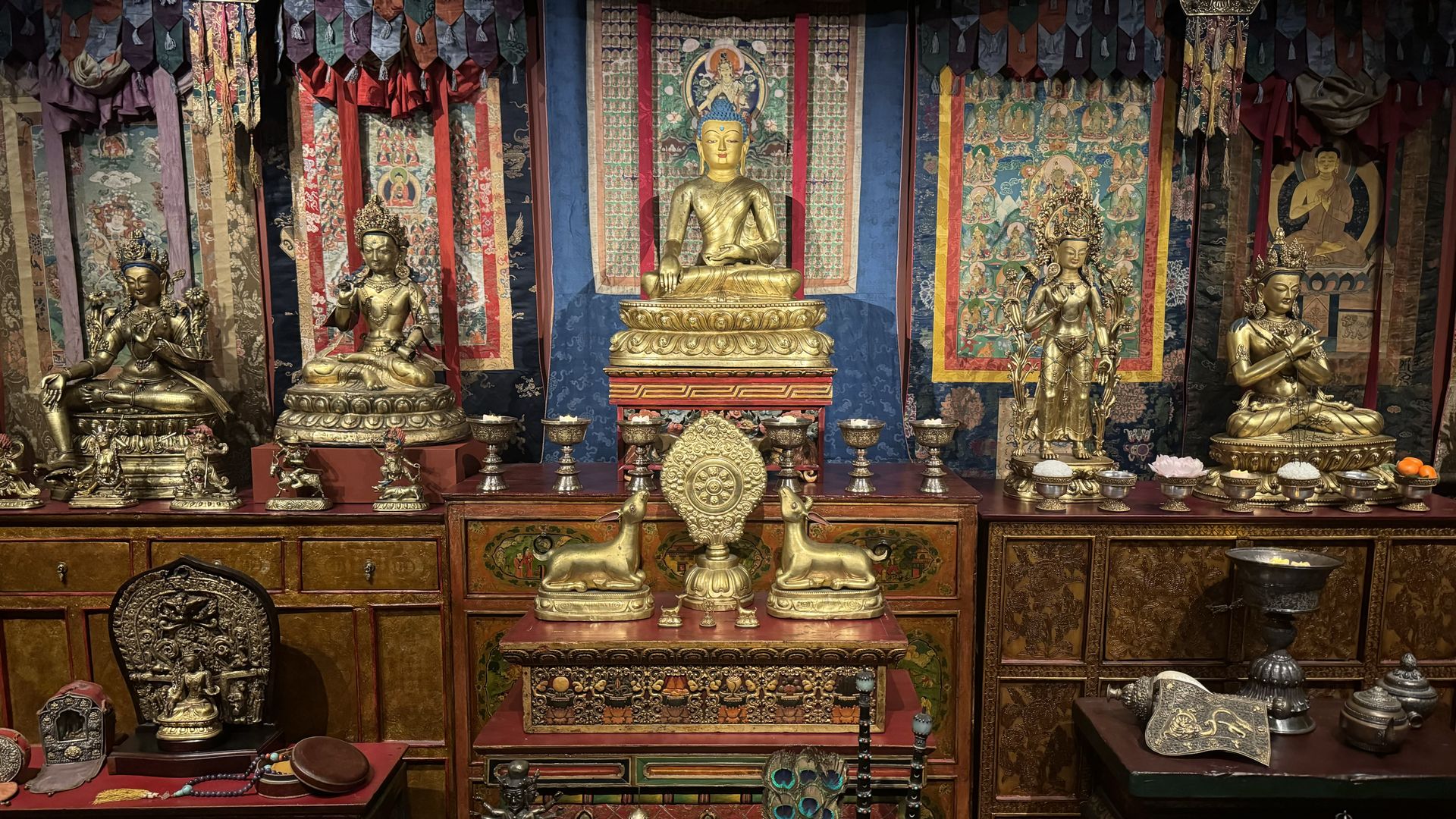A room decorated with silk wall hangings, bronze sculptures and wood cabinets from Tibet.