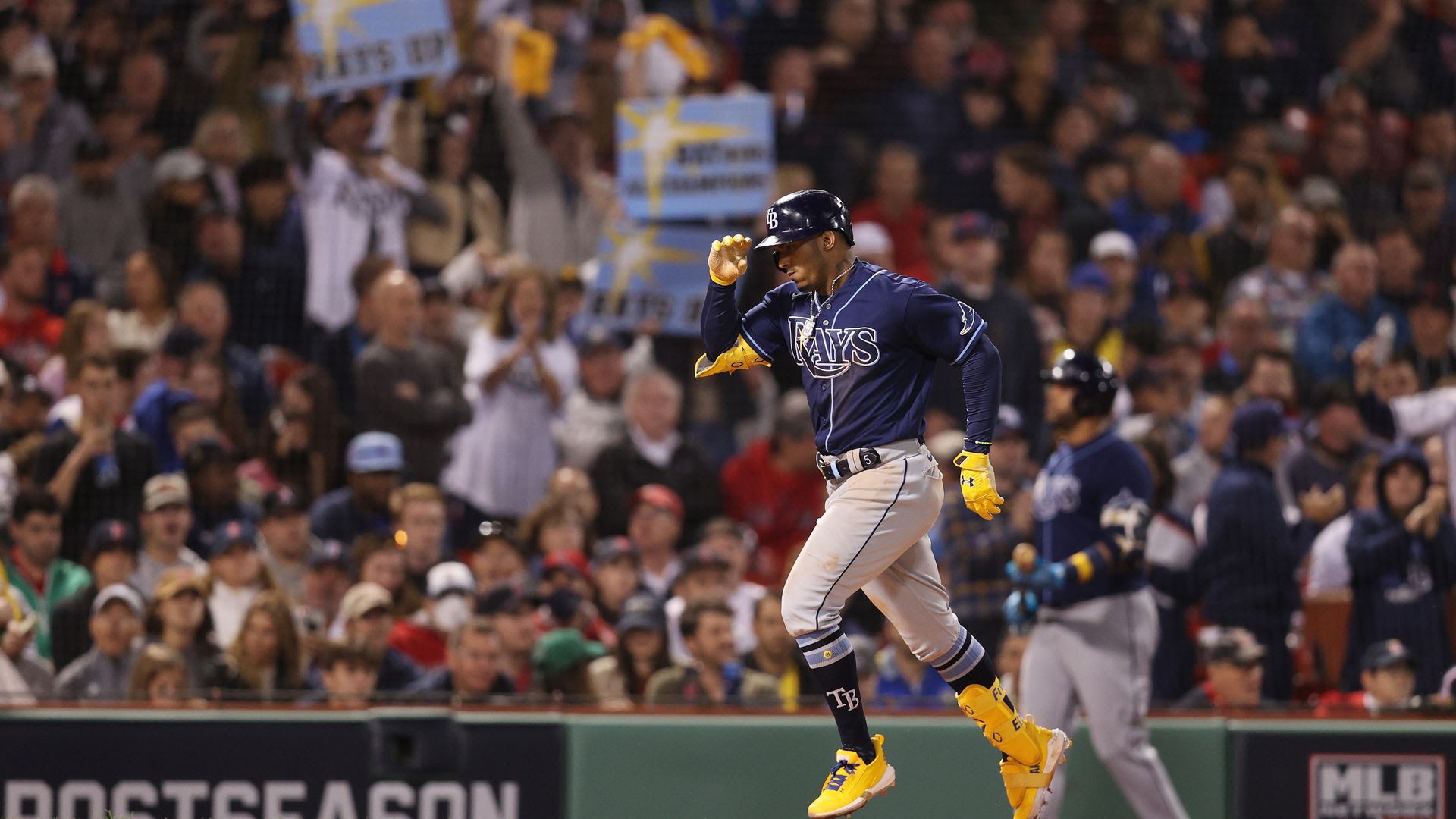 Rays fans celebrate at Fenway Park in Boston during Game 3 of the ALDS as Wander Franco celebrates a home run.