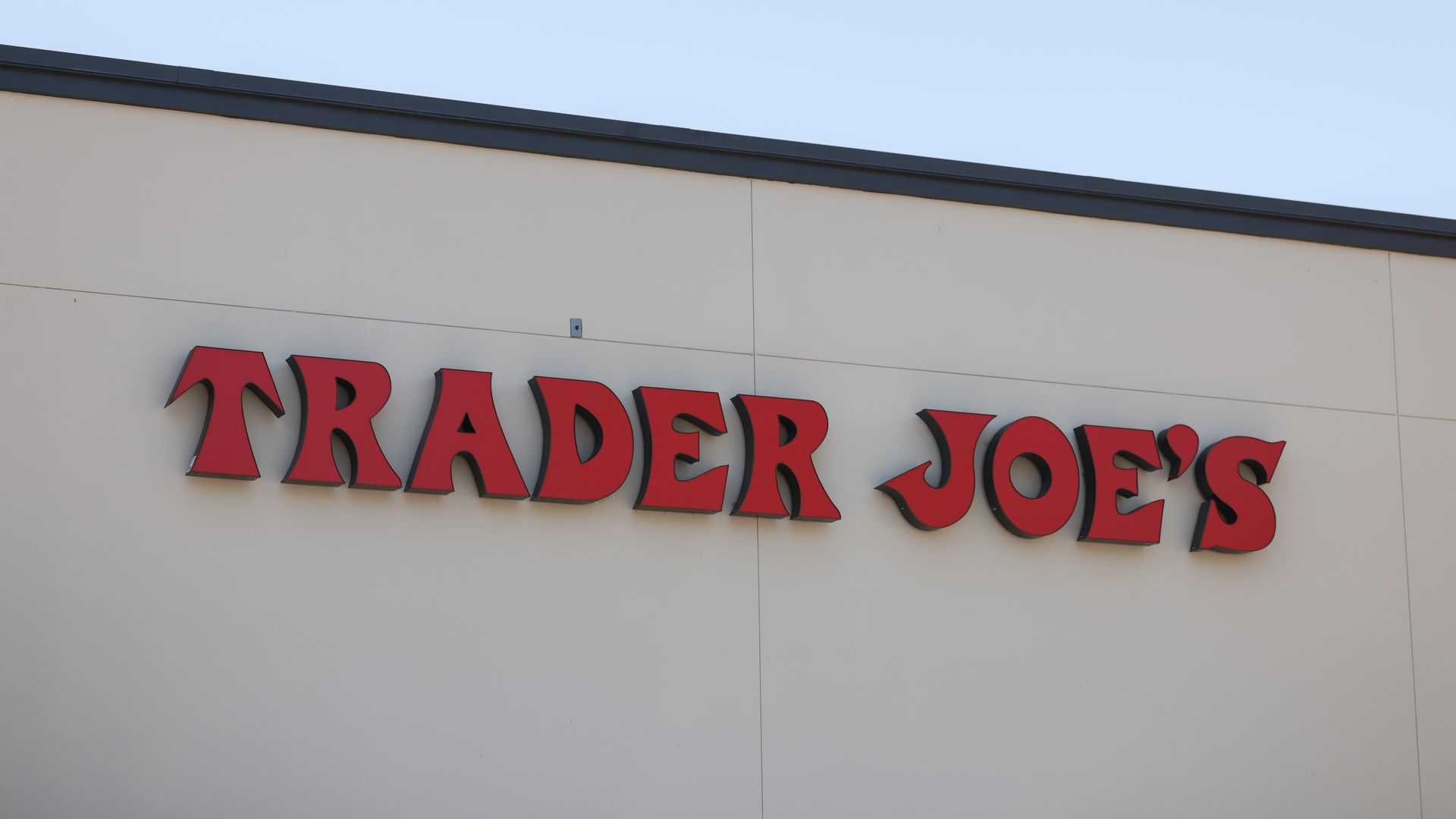 A storefront with a sign in red letters that reads "TRADER JOE'S."