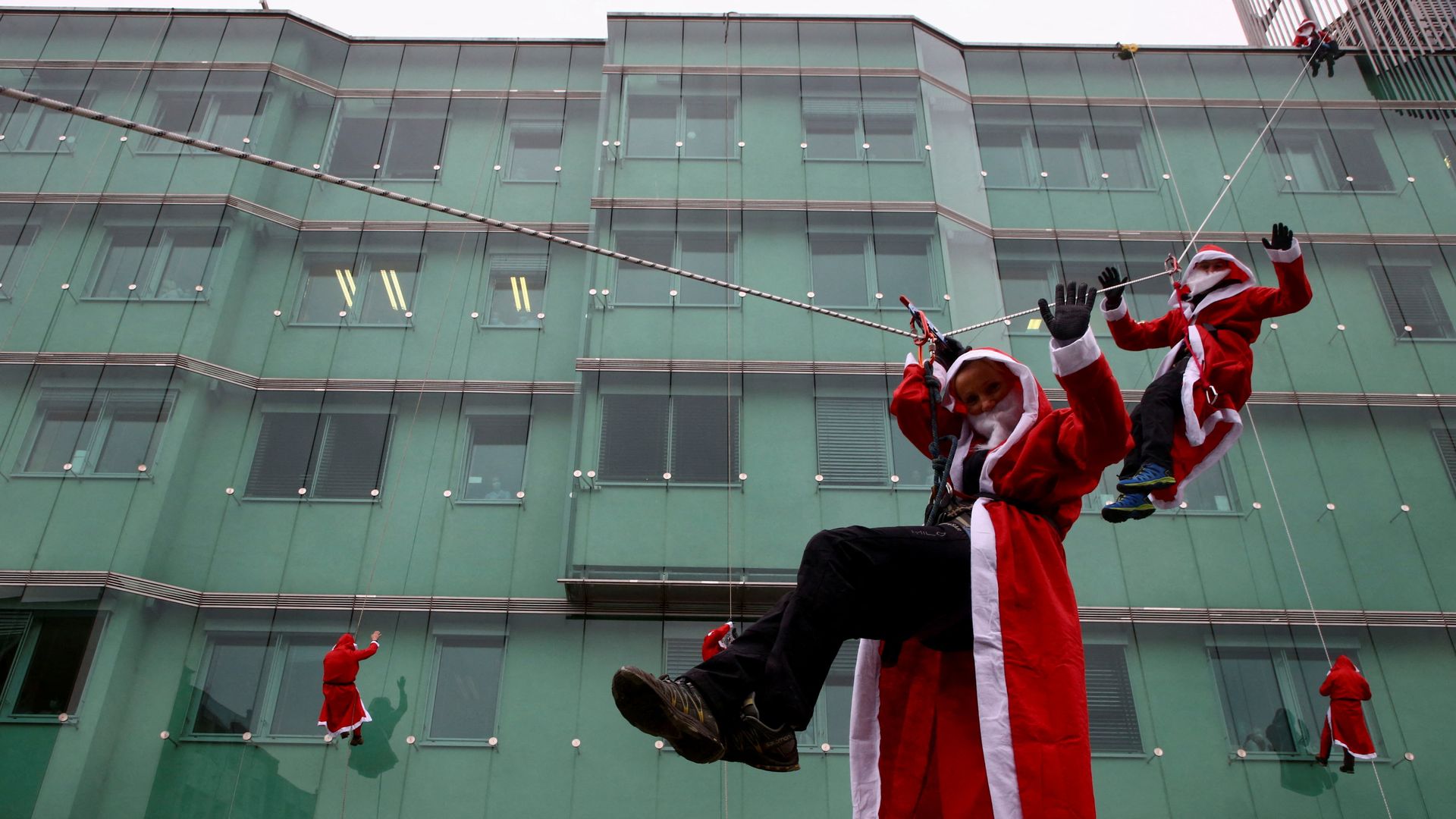 Santas rappelling down a building.