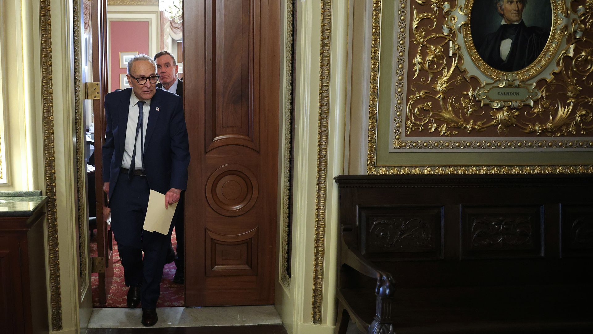 Schumer (left) and Warner walk outside the U.S. Capitol with other senators behind them.