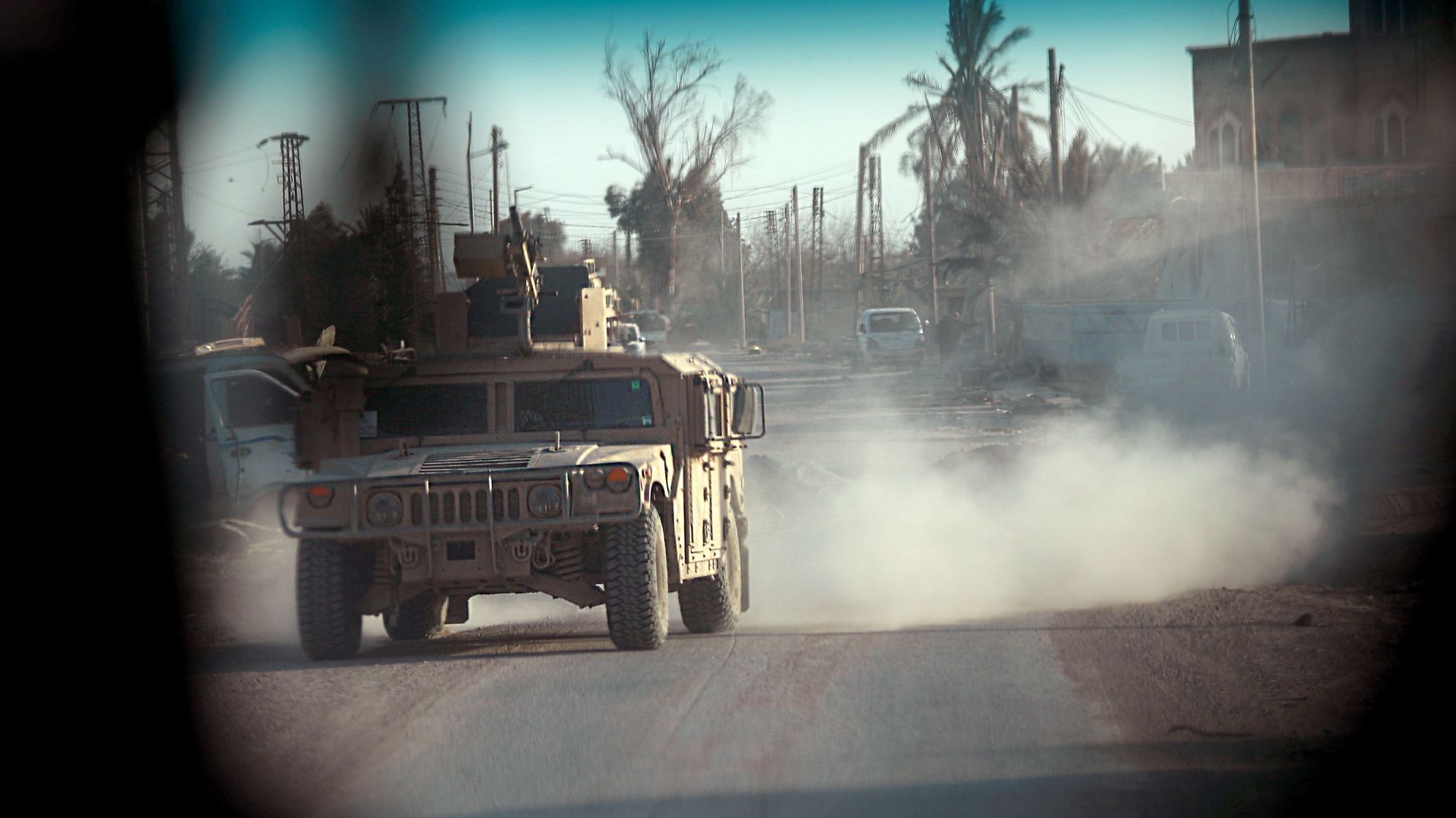 U.S. military vehicle driving through Syrian town.