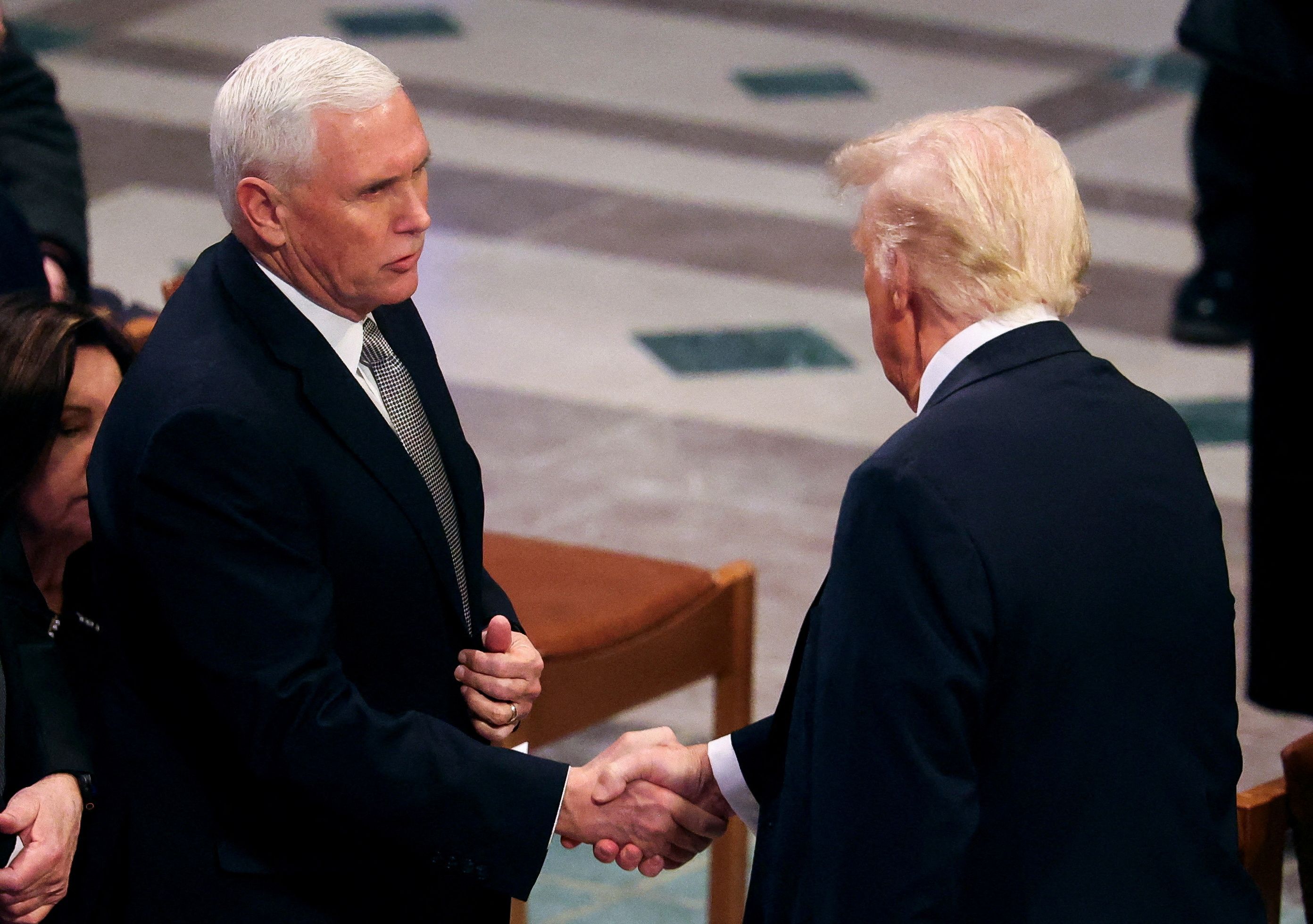 U.S. President-elect Donald Trump shakes hands with former U.S. Vice President Mike Pence on the day of the State Funeral for former U.S. President Jimmy Carter at the Washington National Cathedral in Washington, U.S., January 9, 2025. REUTERS/Brendan McDermid