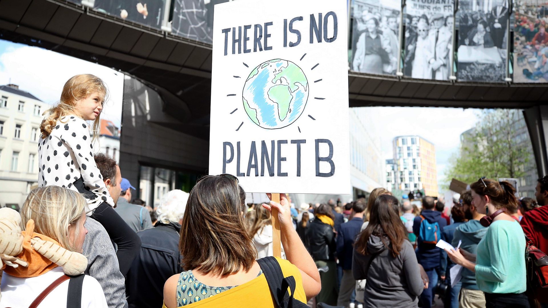 Demonstrators walking, one holding a sign that reads "There is no planet B"