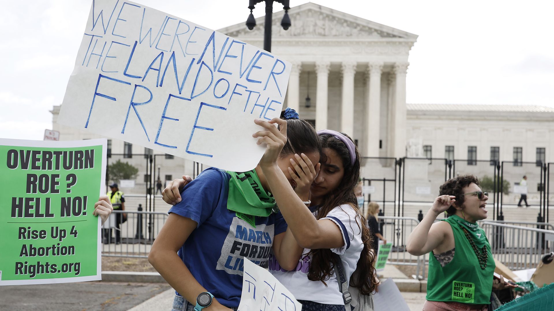 Picture of two girls crying and hugging in front of the Supreme Court