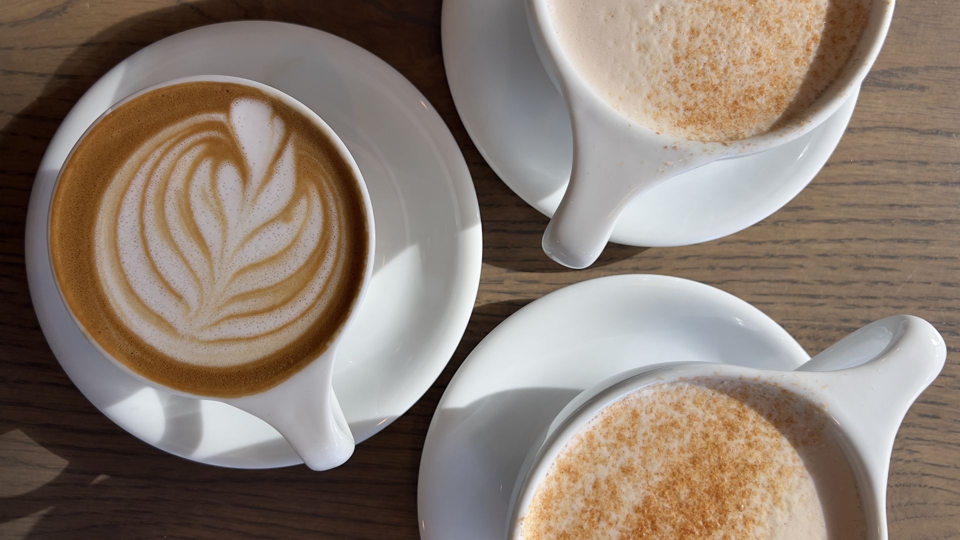 Three coffees on a table. 