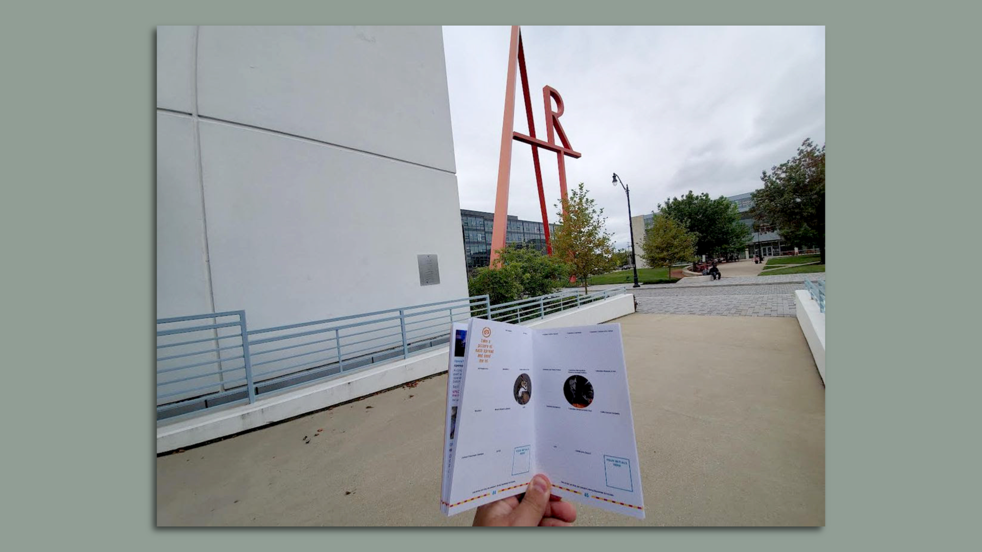 A Columbus "art passport" next to an art school's large sculpture of the word "ART."