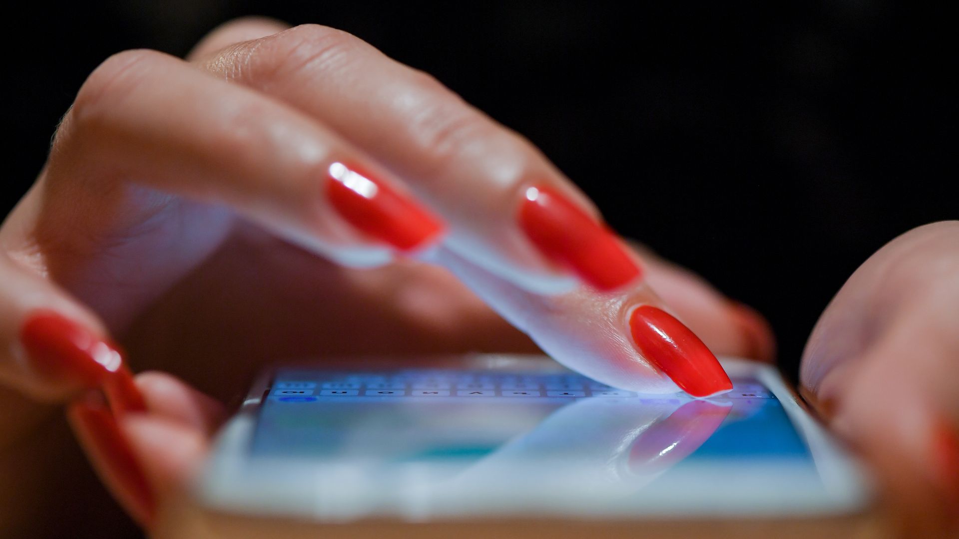 A person's hands on a cellphone.