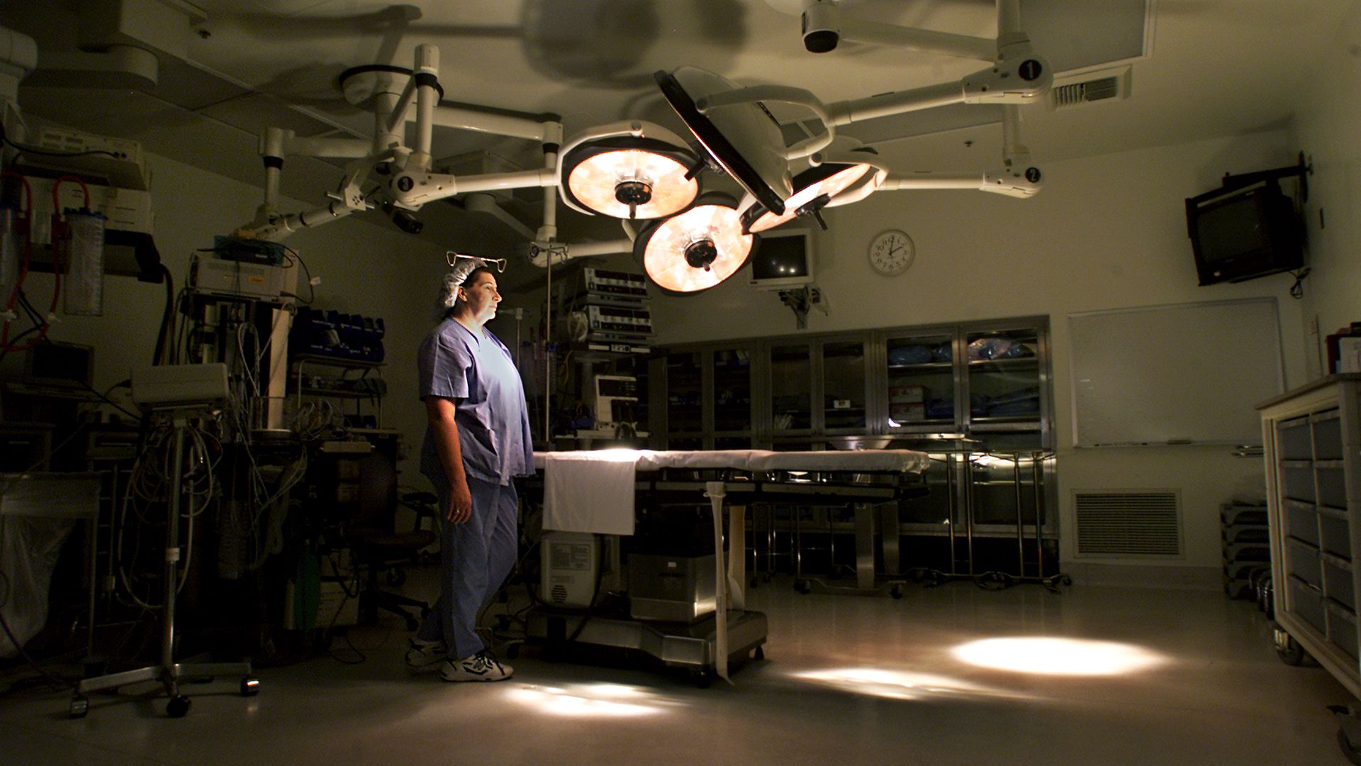 A nurse stands in an operating room.
