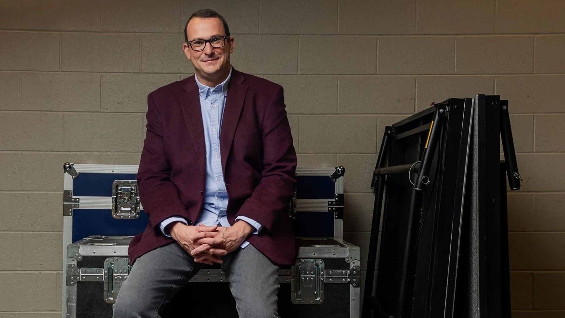Huntsville Music Officer Matt Mandrella sits on backstage music equipment