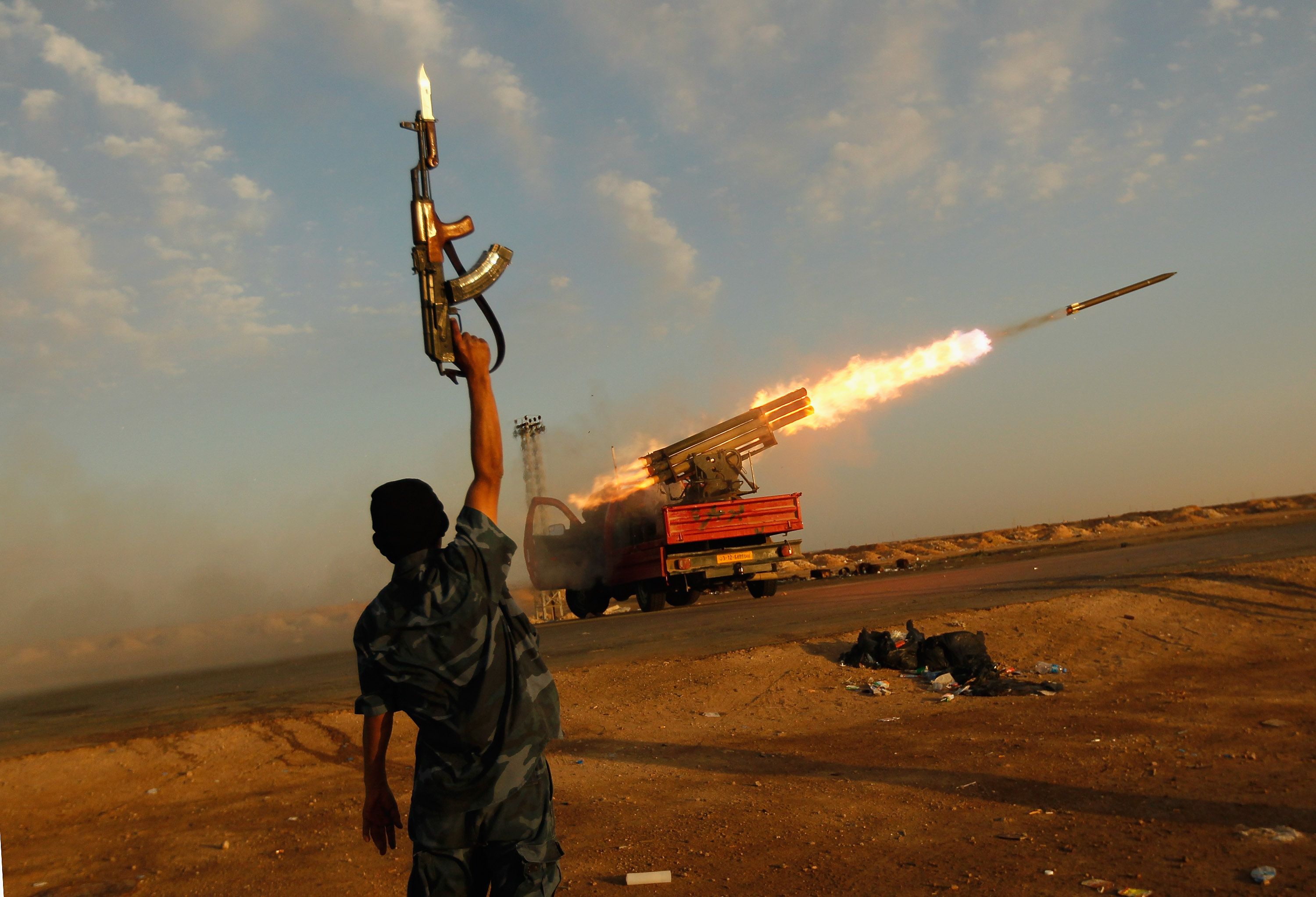 A rebel fighter celebrates as his comrades fire a rocket barrage toward the positions of troops loyal to Libyan ruler Muammar Gaddafi April 14, 2011