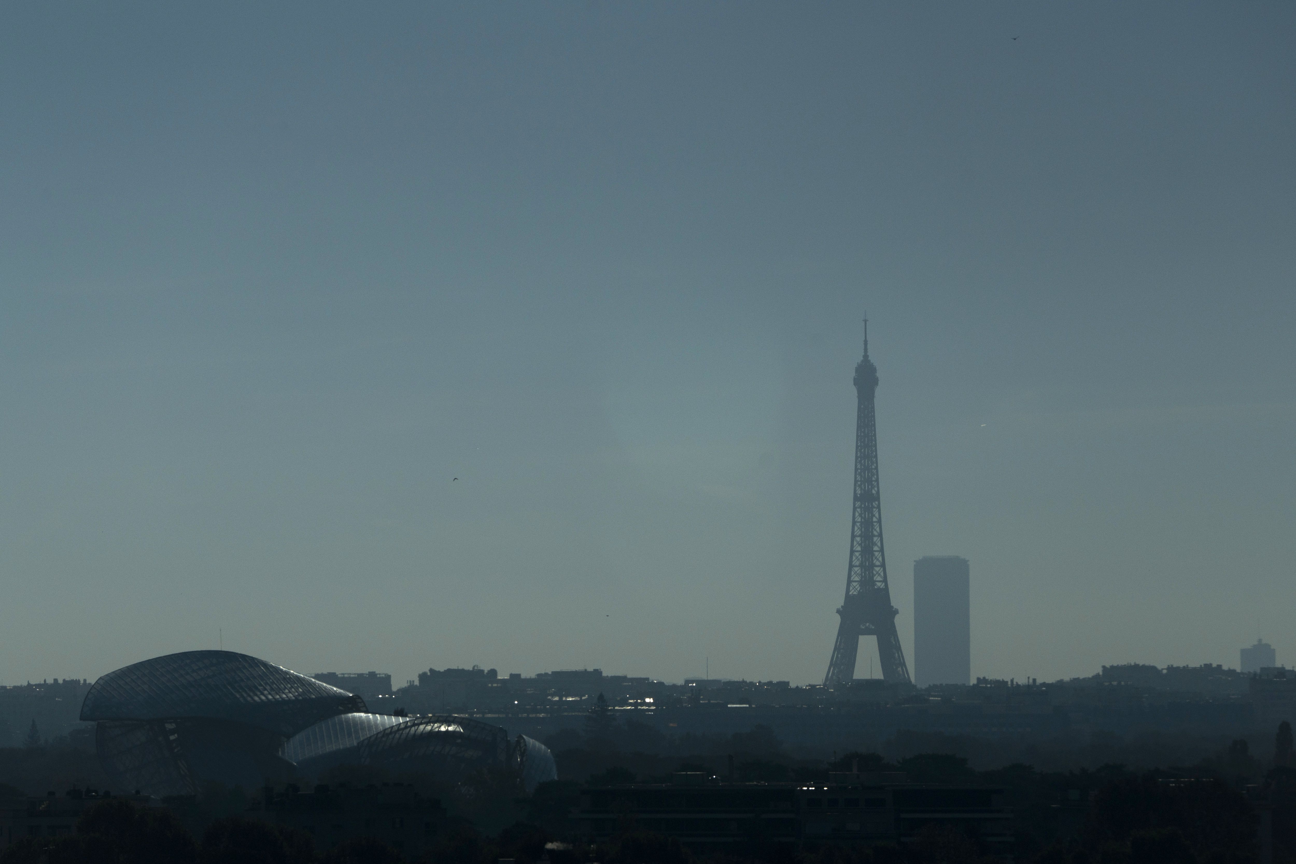 The Eiffel Tower is visible in the distance beyond office towers in the La Défense business district near Paris.