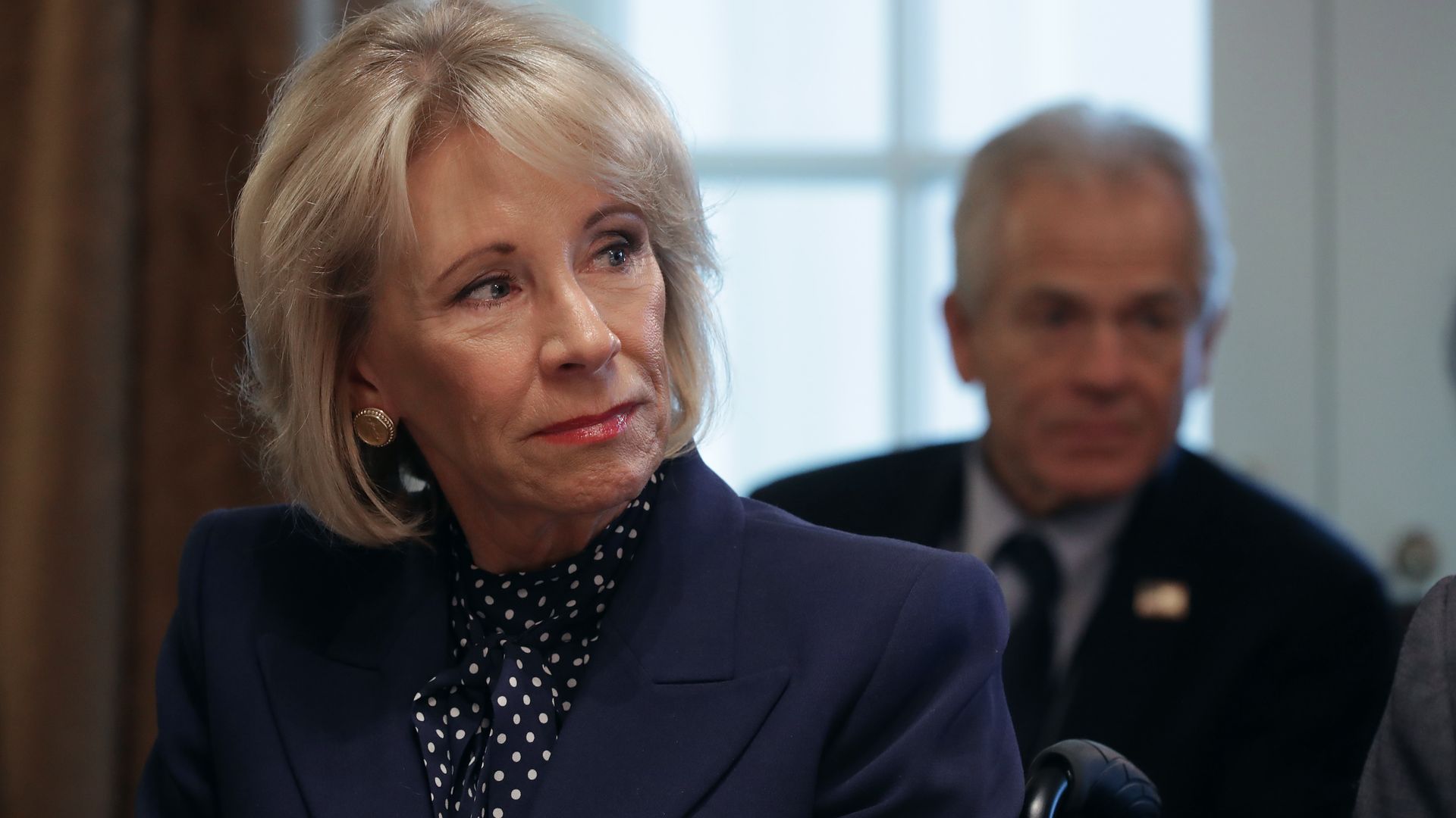 Education Secretary Betsy DeVos sits in a blue suit in a cabinet meeting.