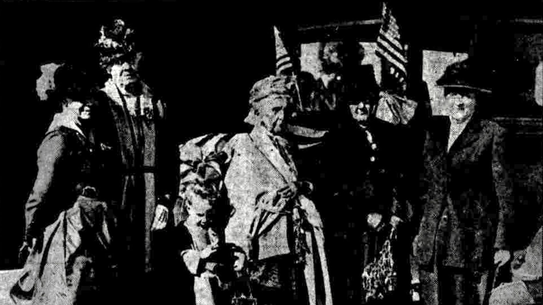 A group of women hold U.S. flags in an old newspaper photo.