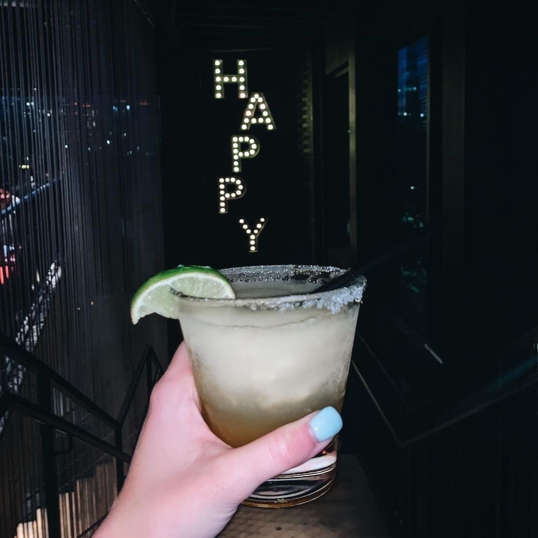 Woman holding cocktail at Happiest Hour in Dallas, Texas
