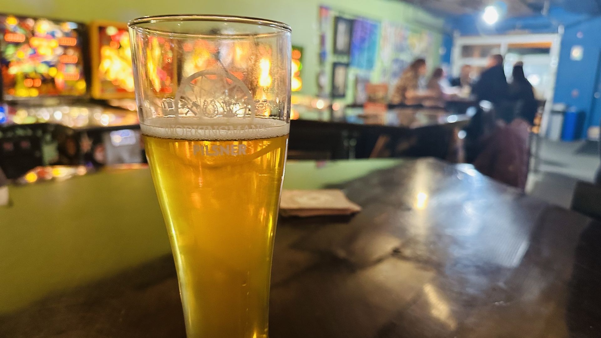 A beer with pinball machines in the background in Indianapolis, Indiana.