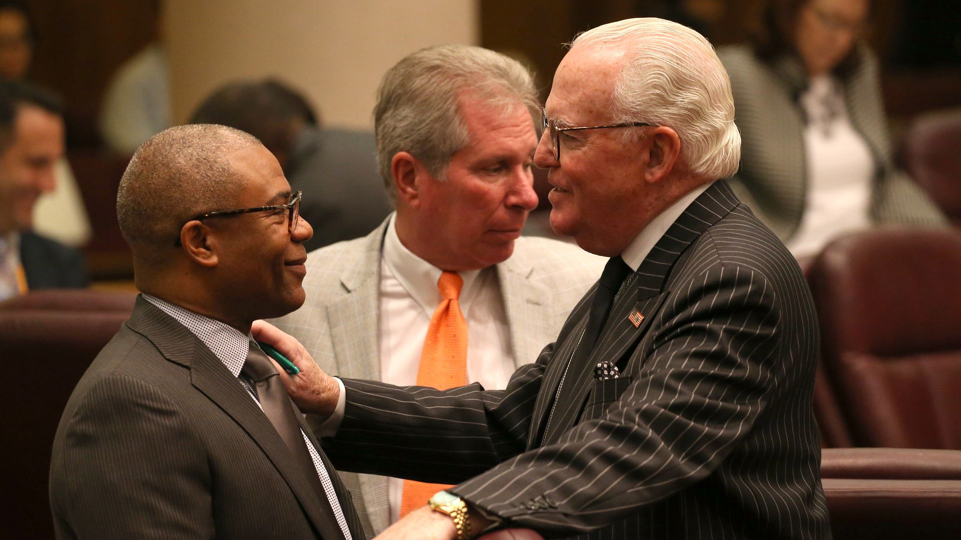 Photo of men talking at a city council meeting. 