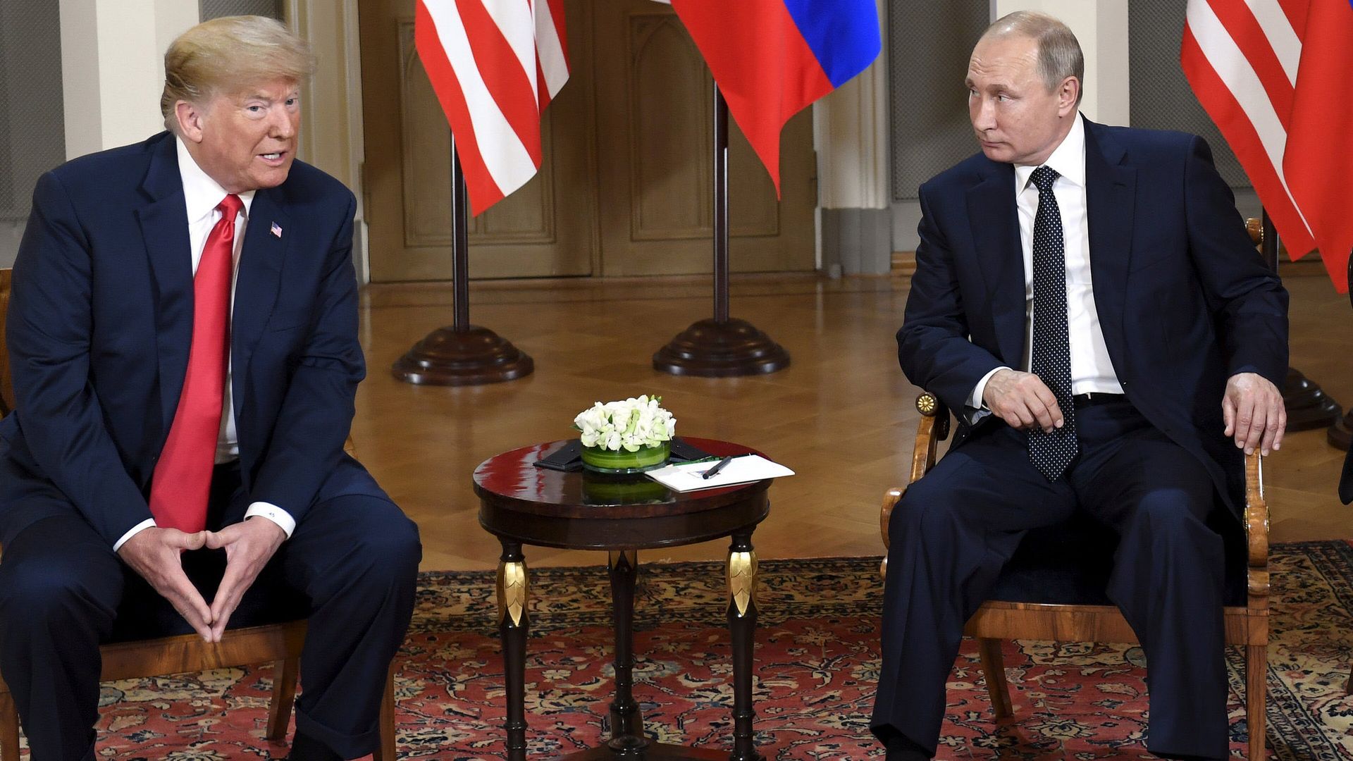 President trump and President putin sitting in chairs next to each other. 