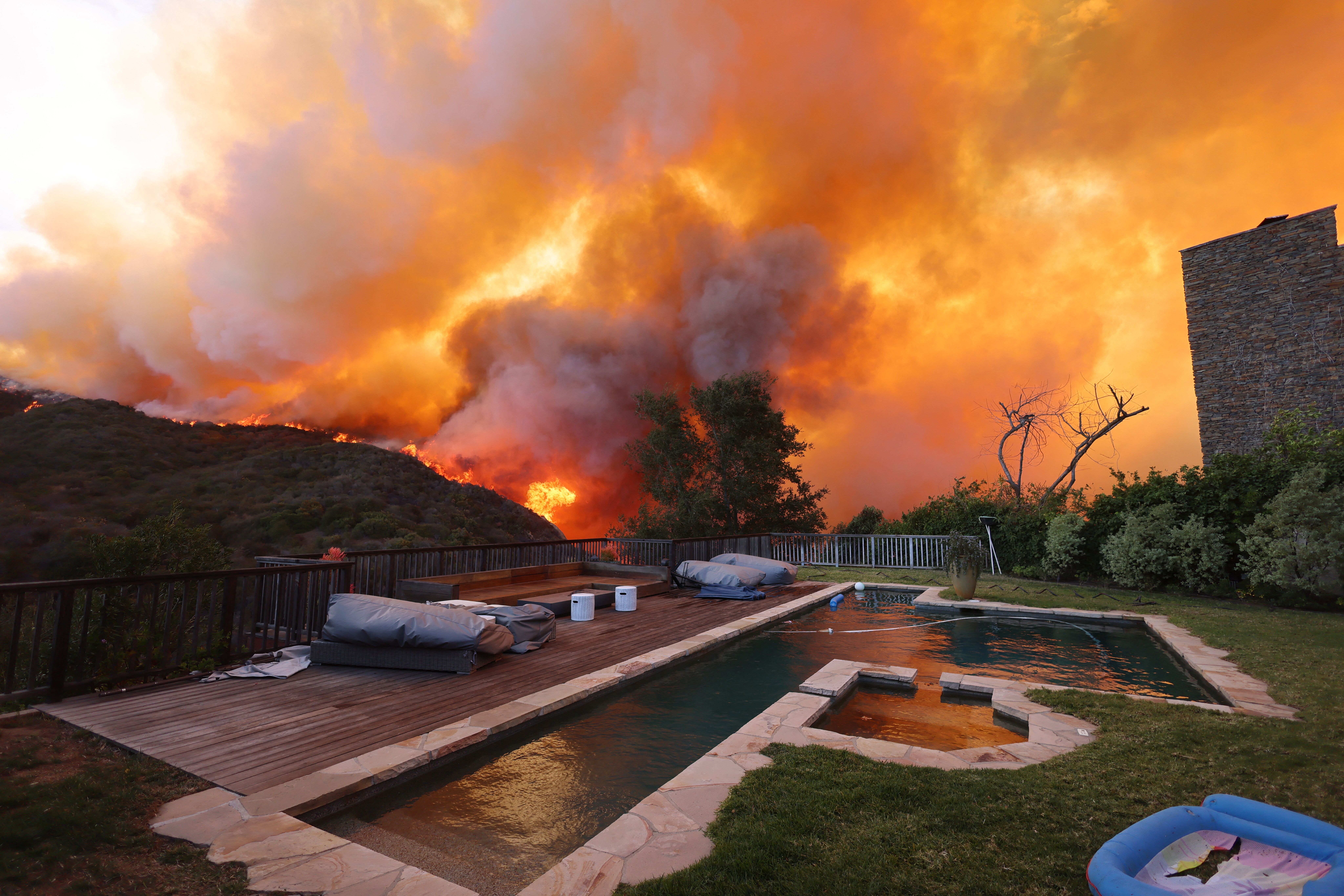 - A brush fire burns near homes in Pacific Palisades, California on January 7, 2025. A fast-moving brushfire in a Los Angeles suburb burned buildings and sparked evacuations Tuesday as "life threatening" winds whipped the region. More than 200 acres (80 hectares) was burning in Pacific Palisades, a 