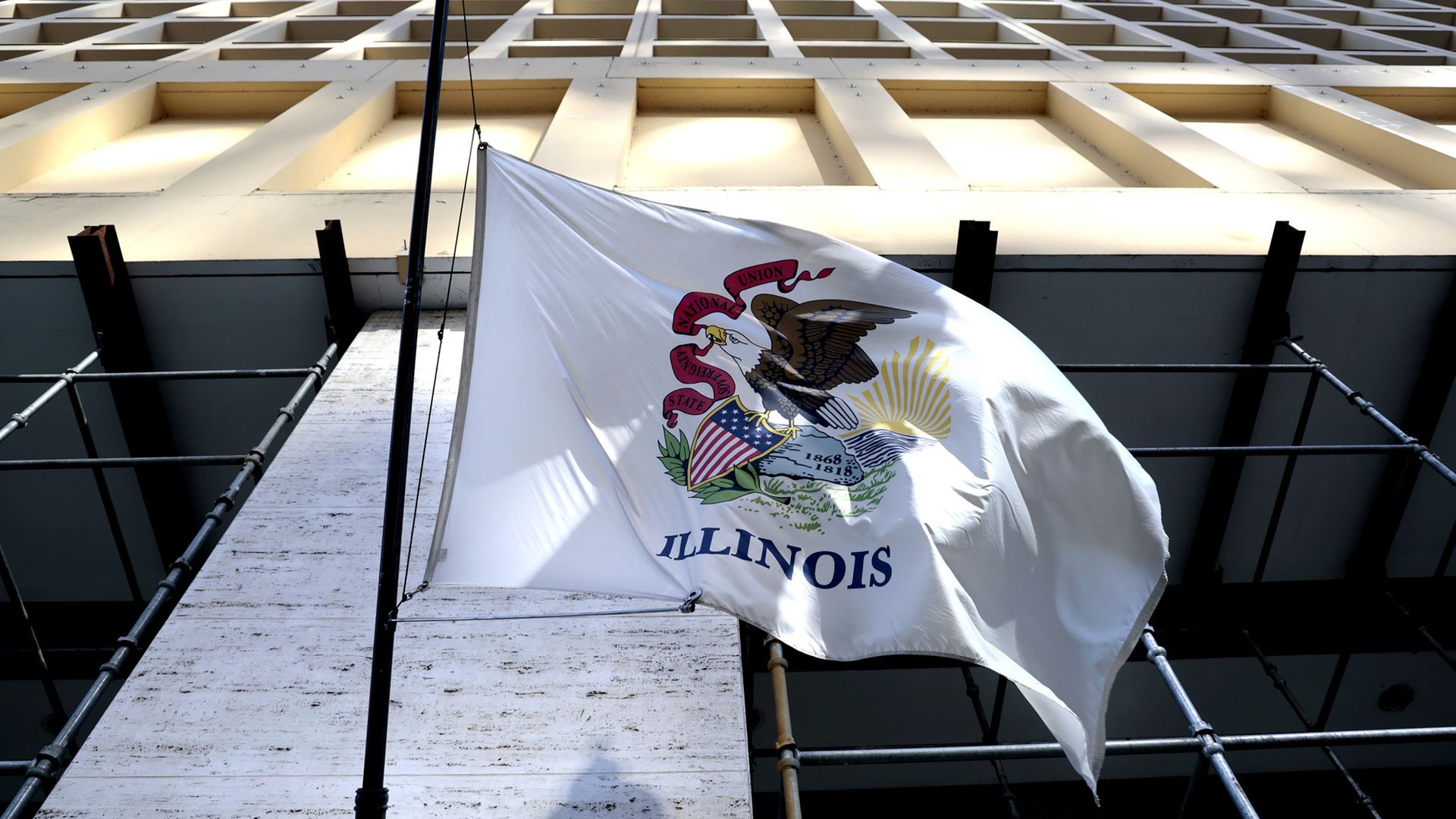 The Illinois state flag waves outside a downtown Chicago building.