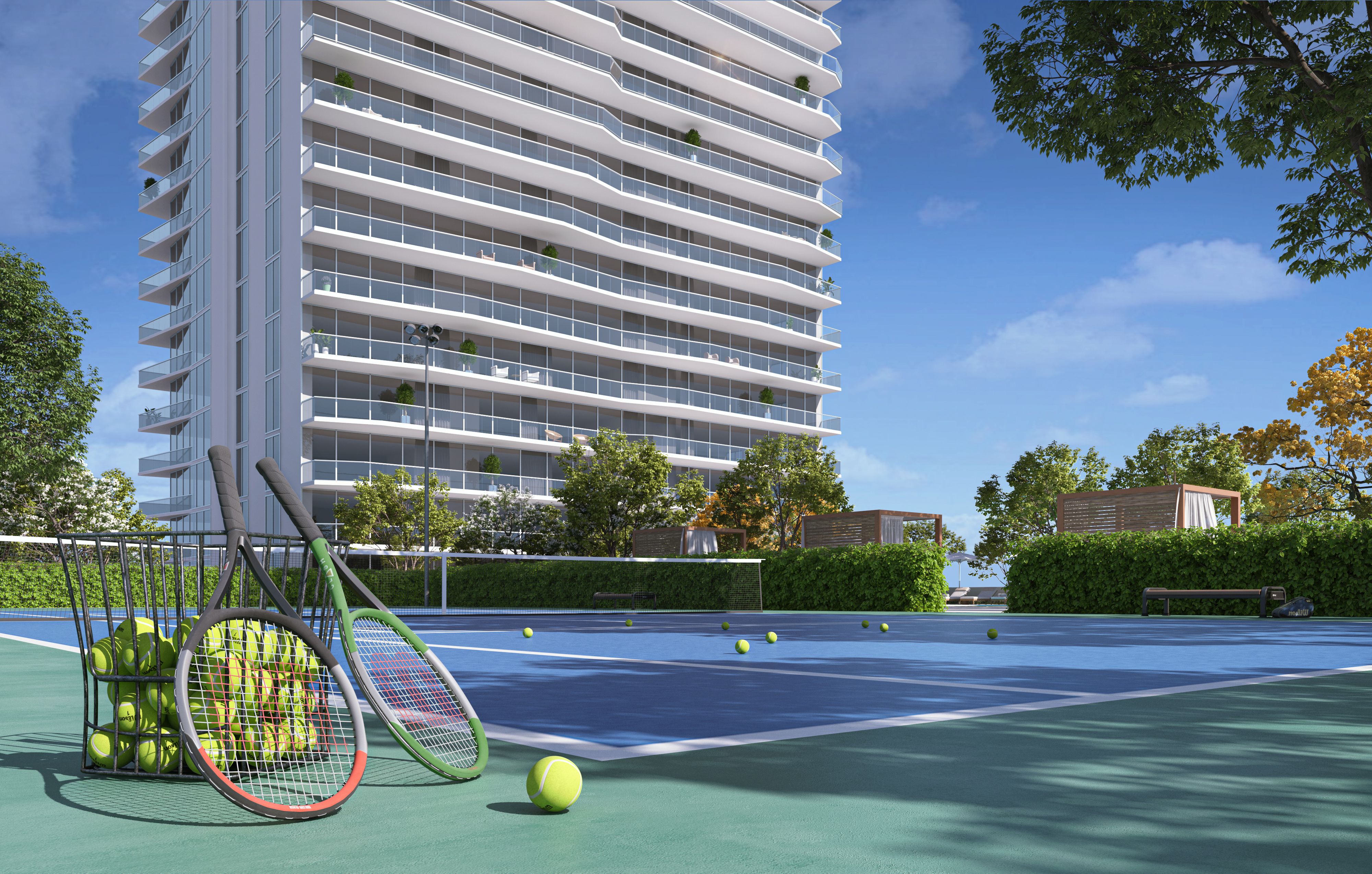 In the foreground, two tennis racquets lean against a basket of tennis balls. In the foreground, a tennis court and first seven floors of Tower II.