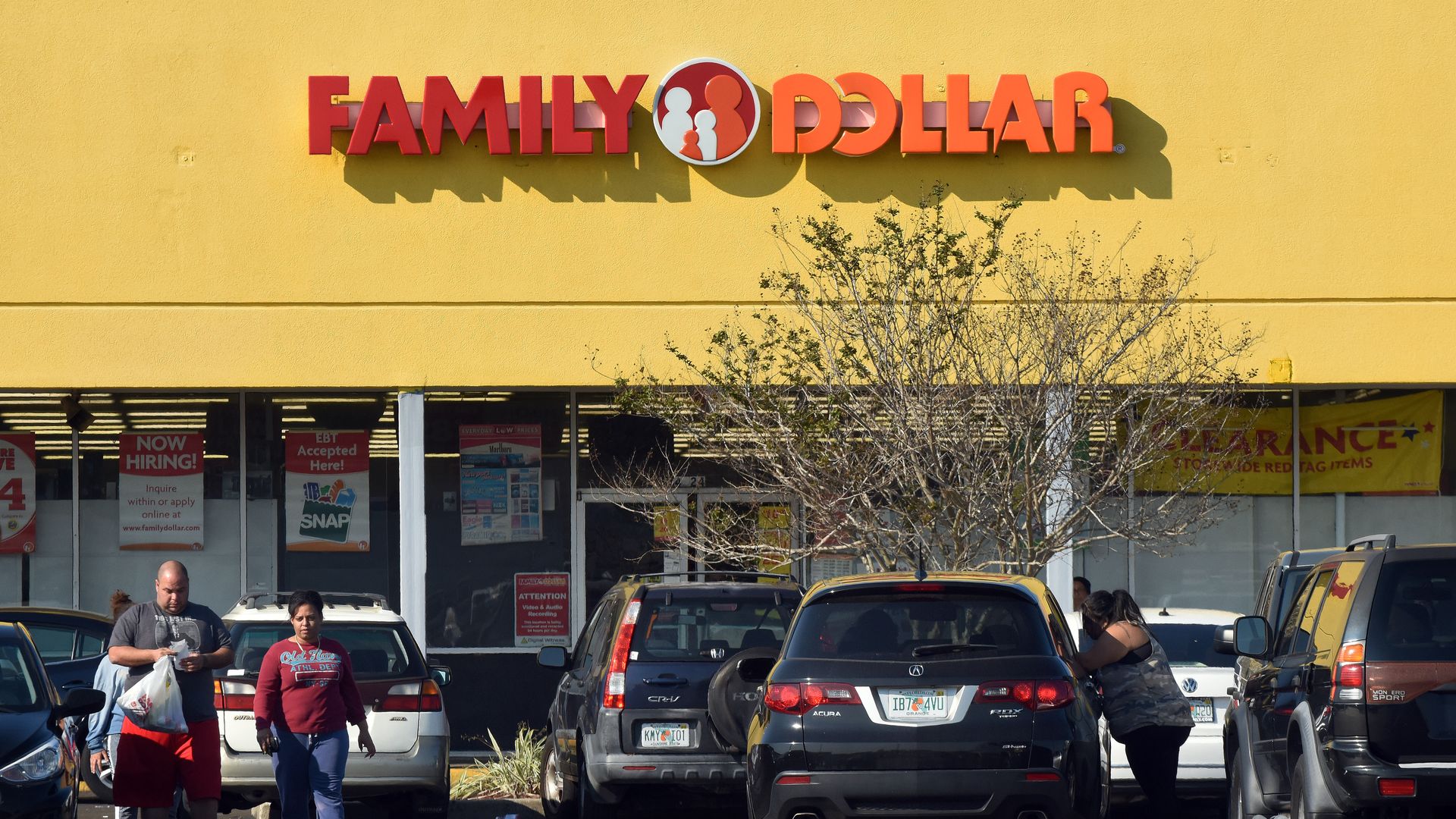 In this image, shoppers walk through the parking lot away from a Family Dollar store. 