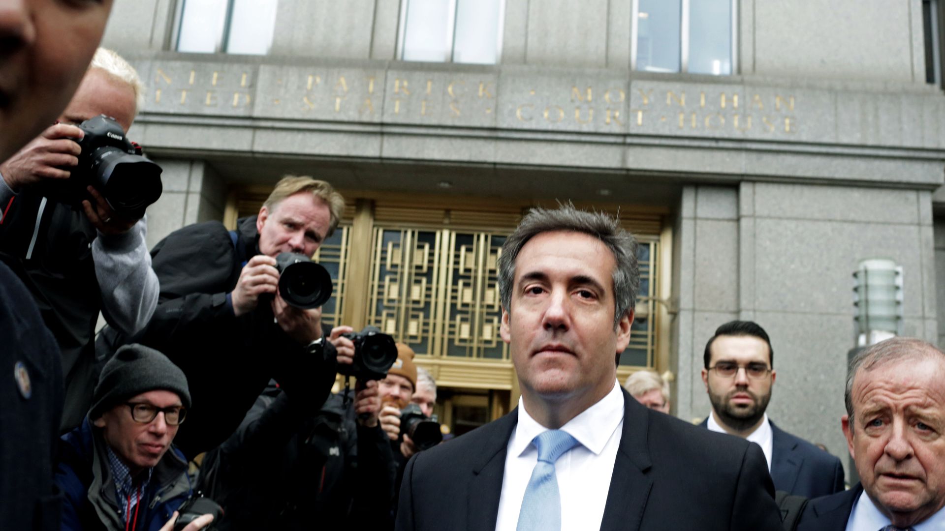 Michael Cohen walking next to photographers.