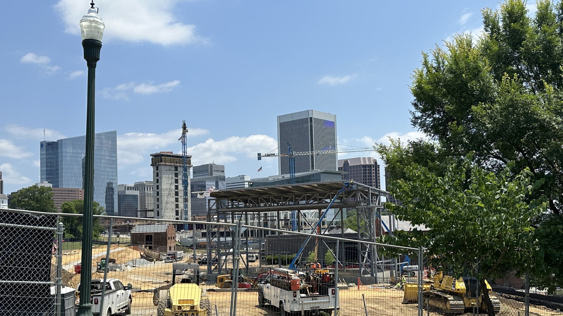 a metal stage is rising in front of the city skyline. 