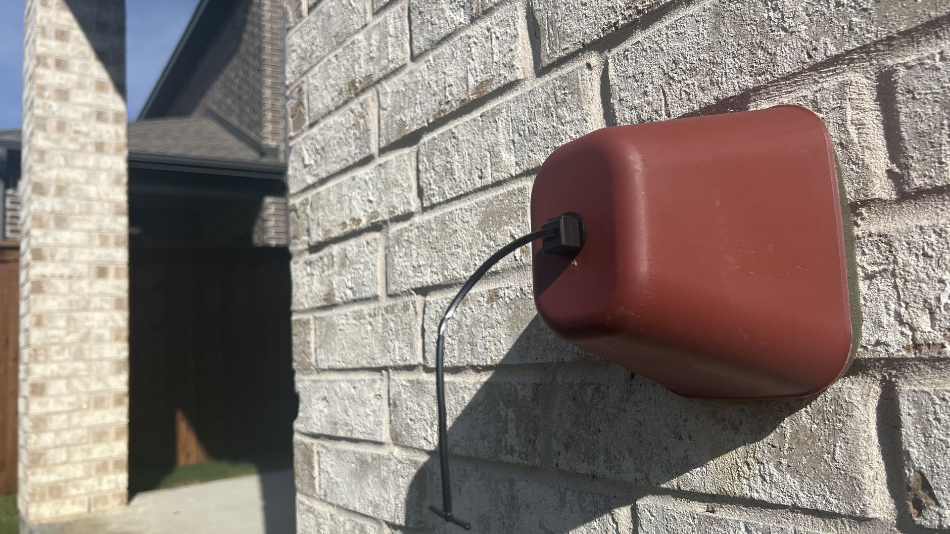 A red foam cover insulates an outdoor water faucet