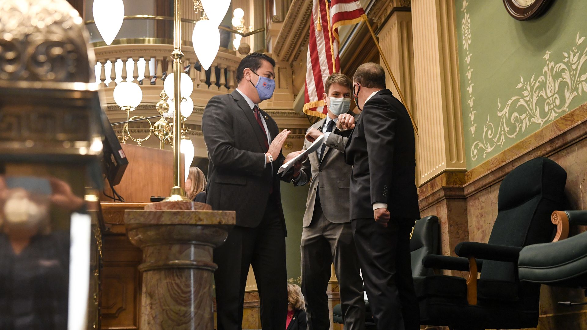 Gov. Jared Polis elbow bumps House Speaker Alec Garnett after being introduced by Senate President Leroy Garcia (left) ahead of a joint address Feb. 17. 