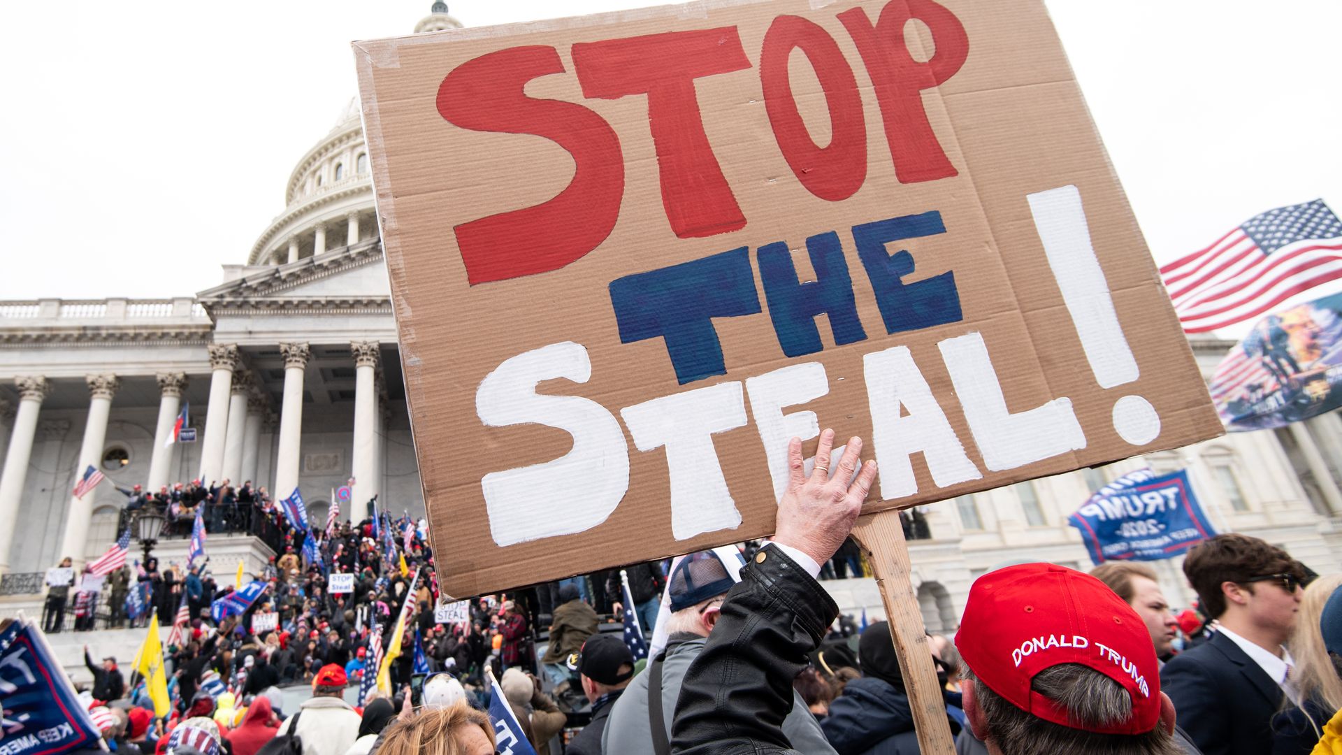  A man holds a stop the steal sign as rioters take over the steps of the Capitol on the East Front on Wednesday, Jan. 6, 2021, as the Congress works to certify the electoral college votes. (Photo By Bill Clark/CQ-Roll Call, Inc via Getty Images)