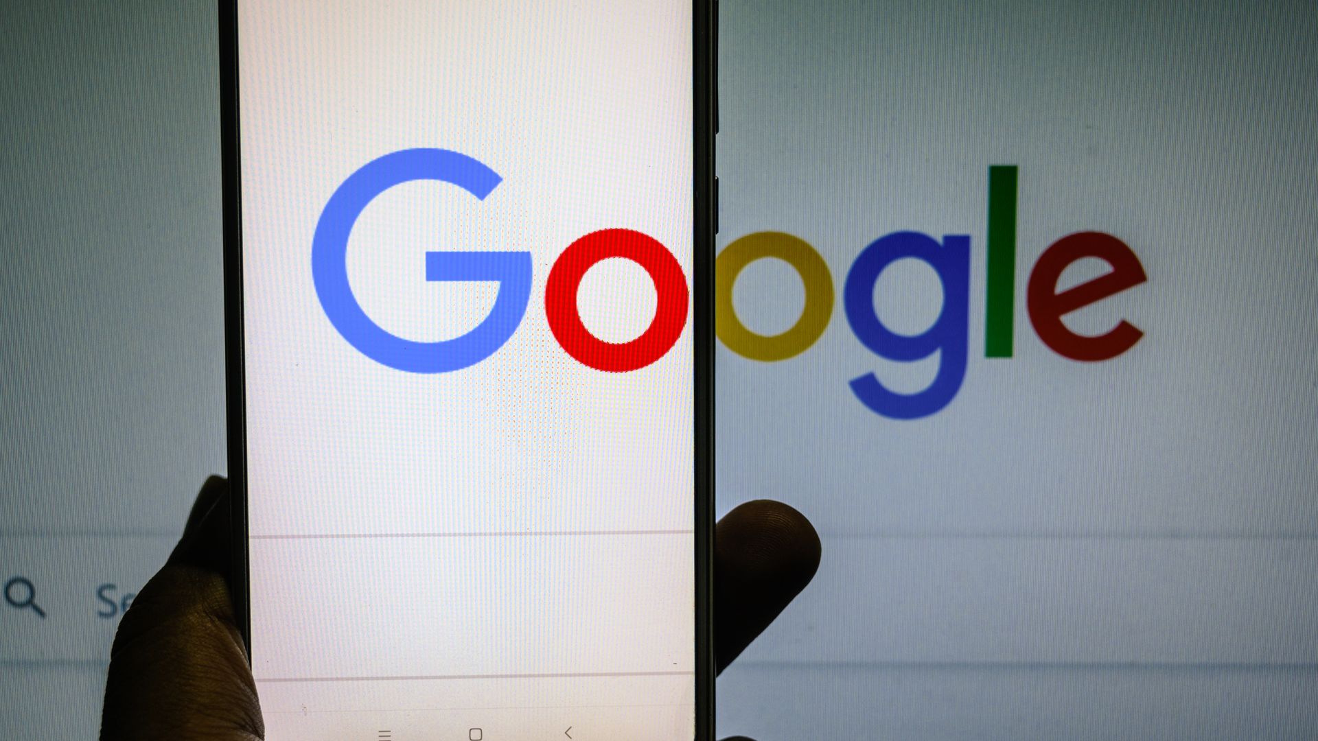 A phone in front of the Google logo