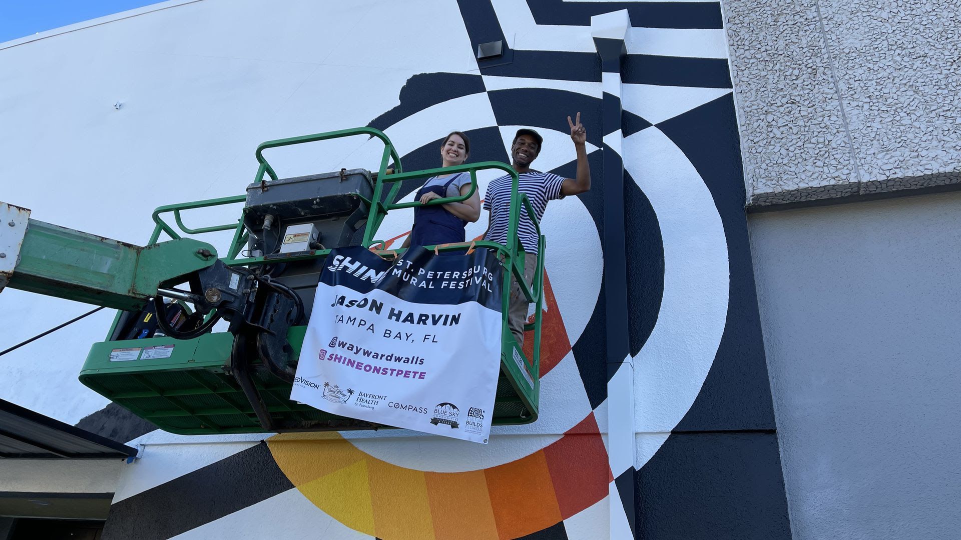 Vera Herrera and Jason Harvin work on his SHINE mural festival piece. 