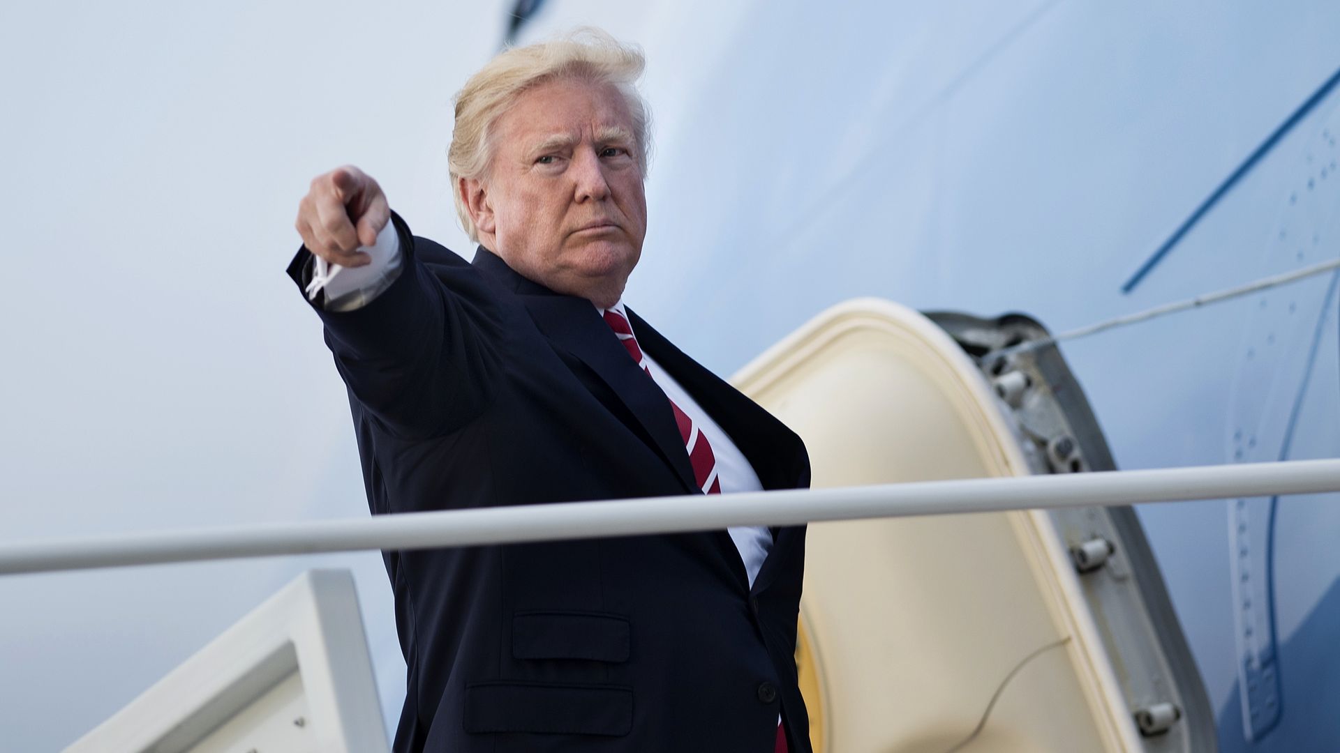 President Trump points as he boards Air Force One