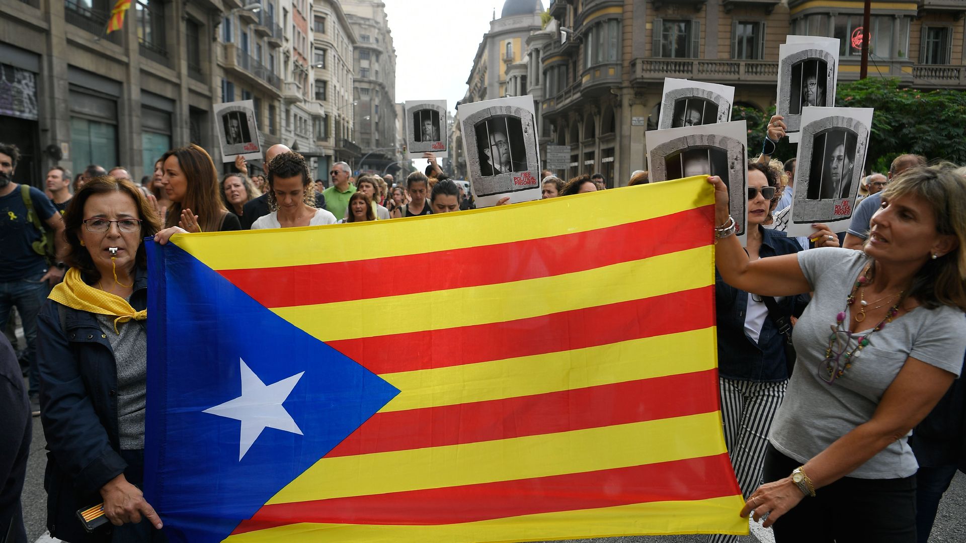 Women hold a Catalan pro-independence "Estelada" flag in Barcelona on October 14