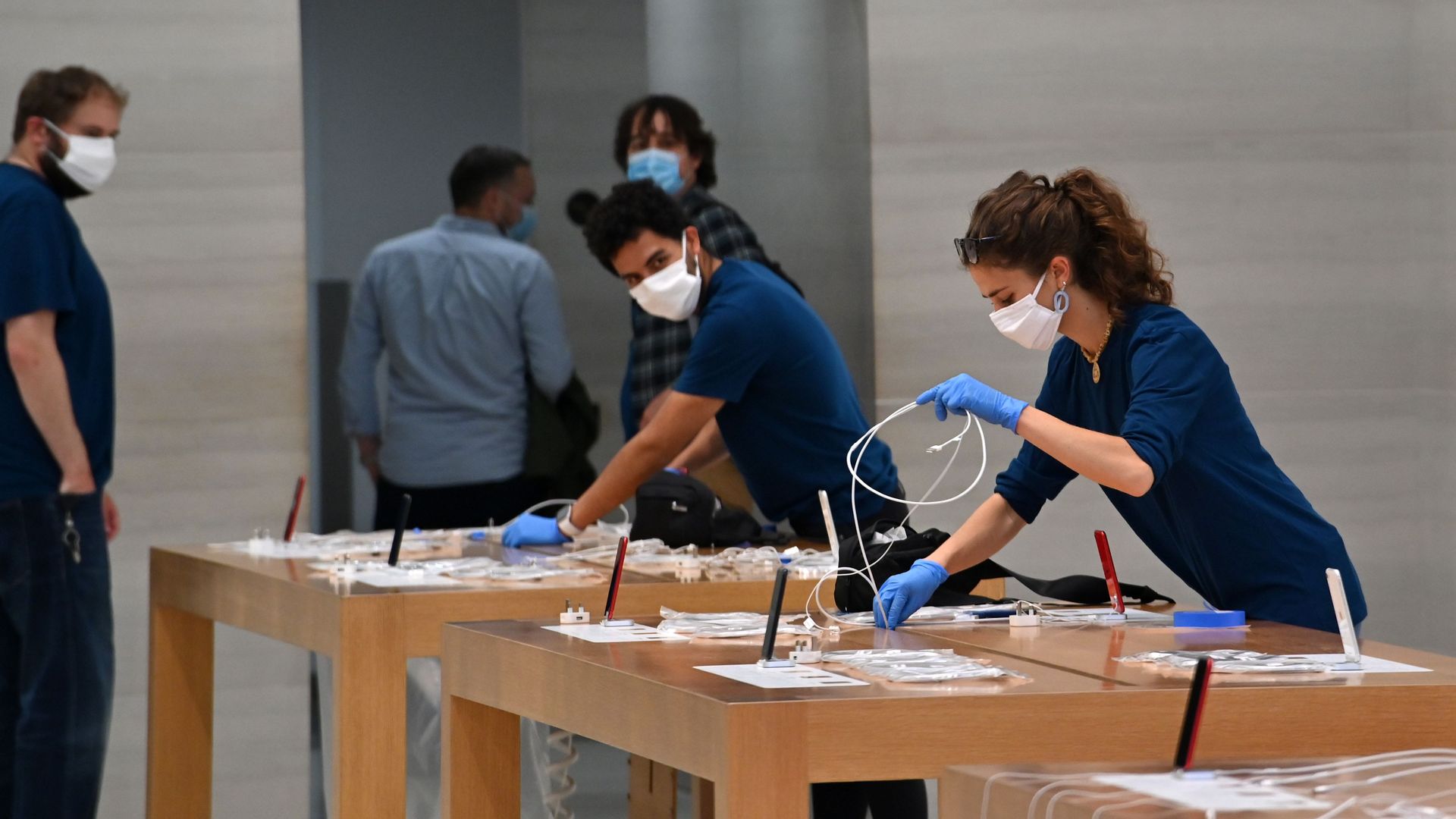 Apple store employees wear protective equipment and clean down stations. Photo: JUSTIN TALLIS/AFP via Getty Images
