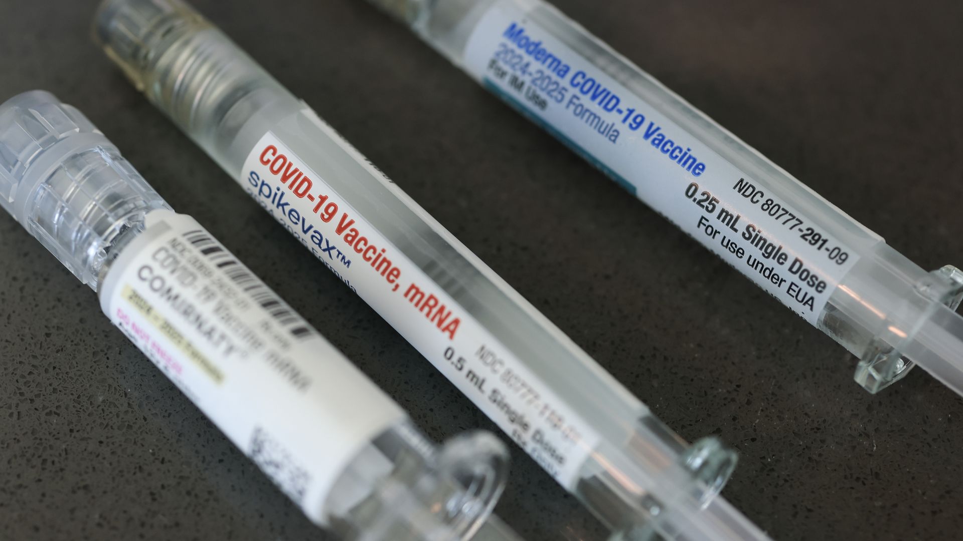 Three syringes of COVID vaccines.