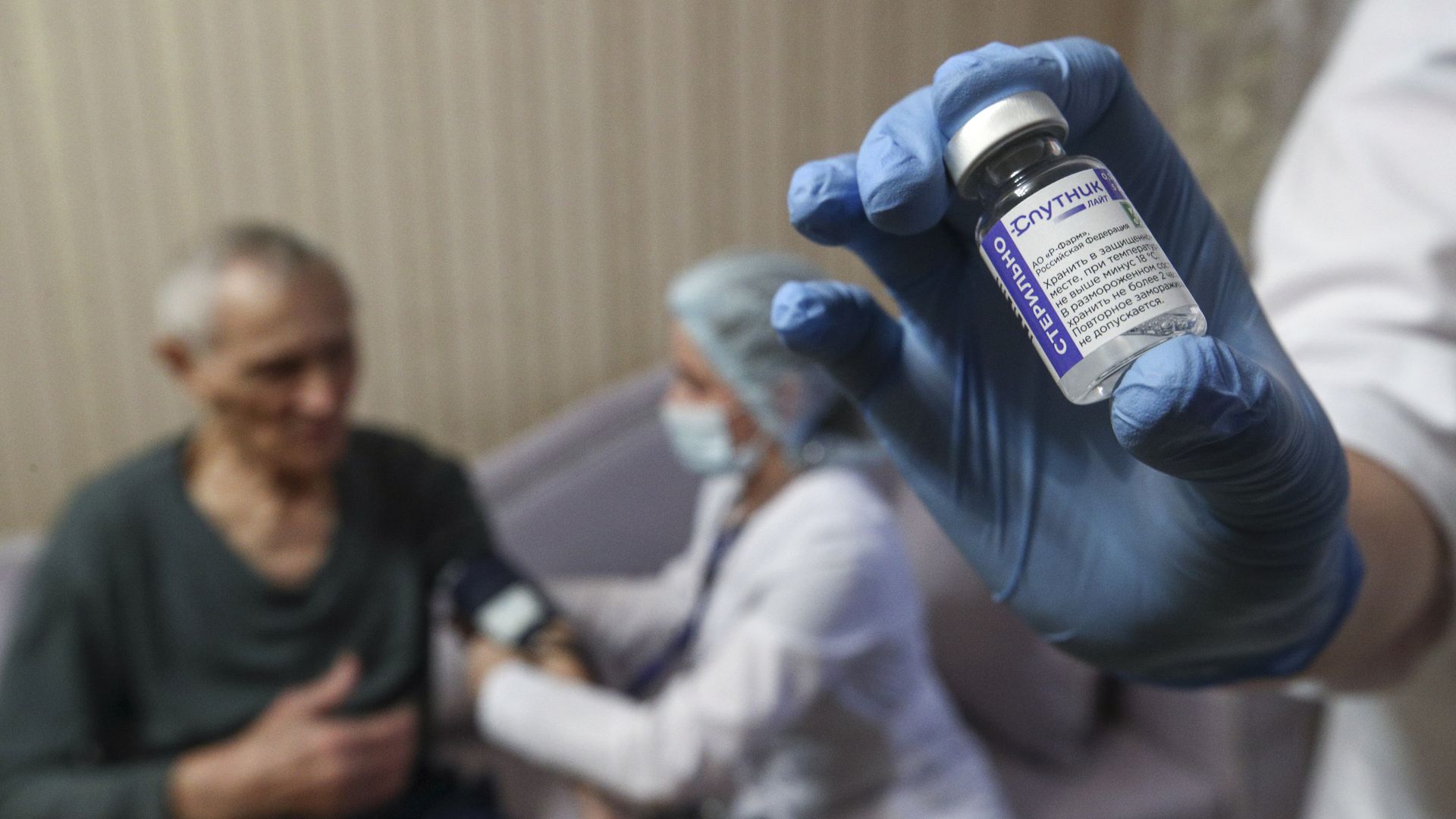 An elderly patient receives the Sputnik Light vaccine against COVID-19 during a home vaccination visit in Kazan, Tatarstan.
