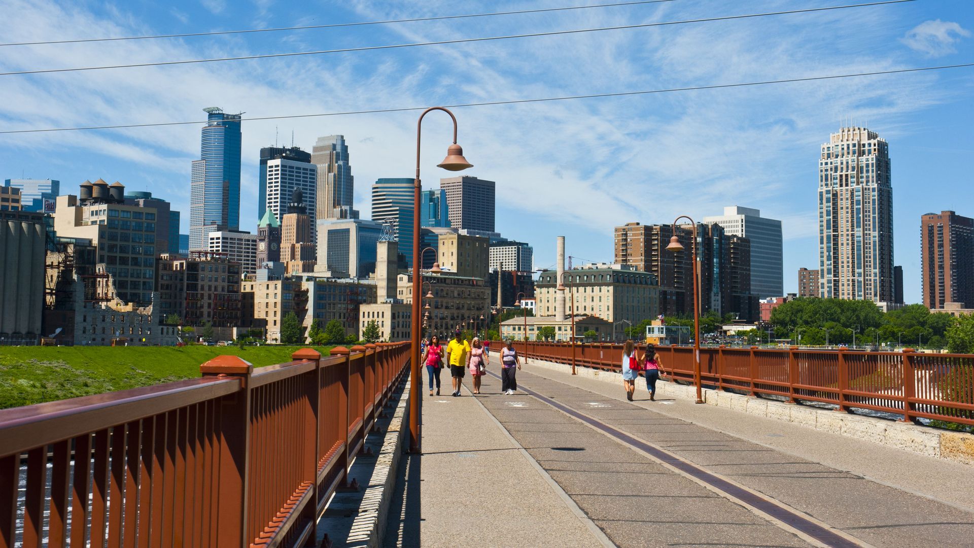 A photo of people walking across the Stone Arch bridge in Minneapolis 