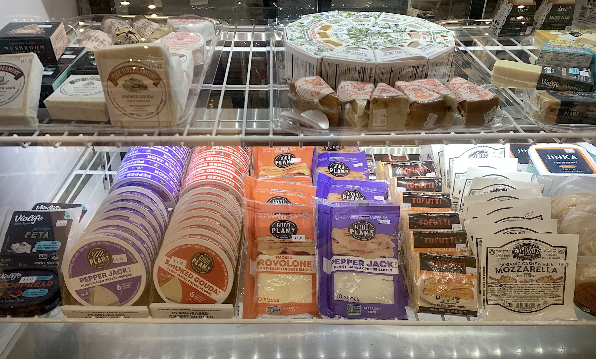 Cheeses in a grocery deli case.